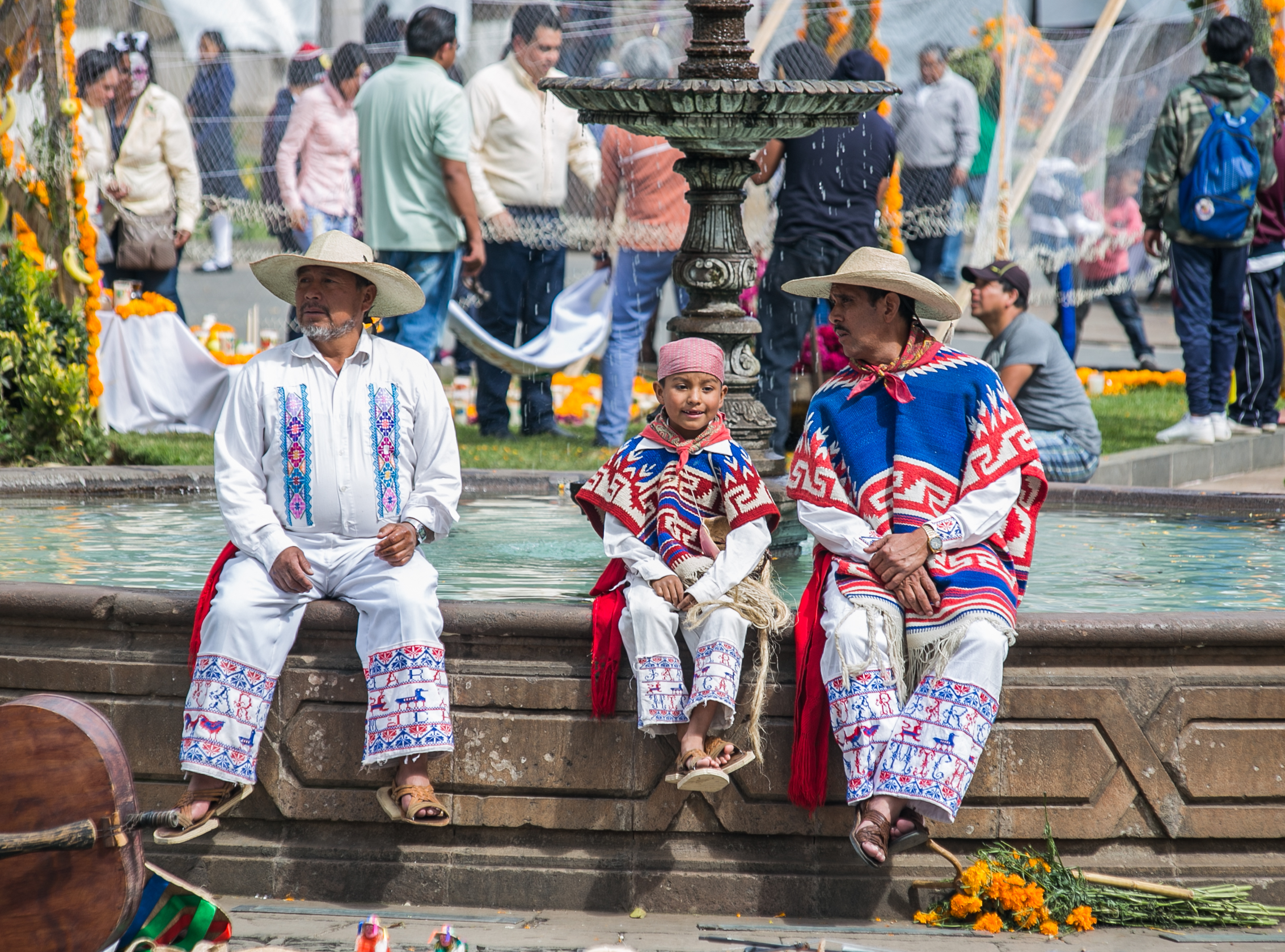  10/31/17 - 2:00pm - Dancers, dressed in traditional performance-wear, take a break on the side of the fountain in the Patzcuaro town square. 