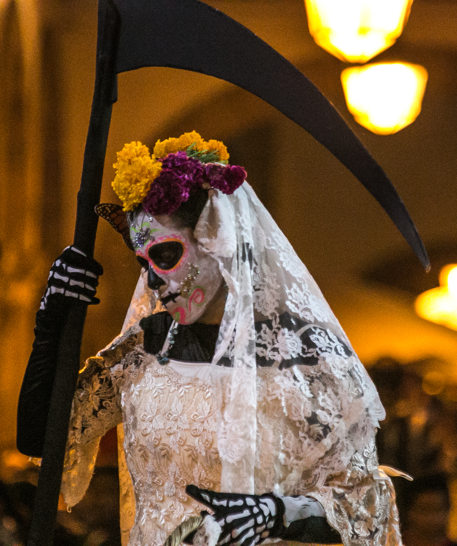  10/31/17 - 7:00pm - A woman with celebratory face paint walks throughout the Patzcuaro town square posing for photos with excited tourists.  