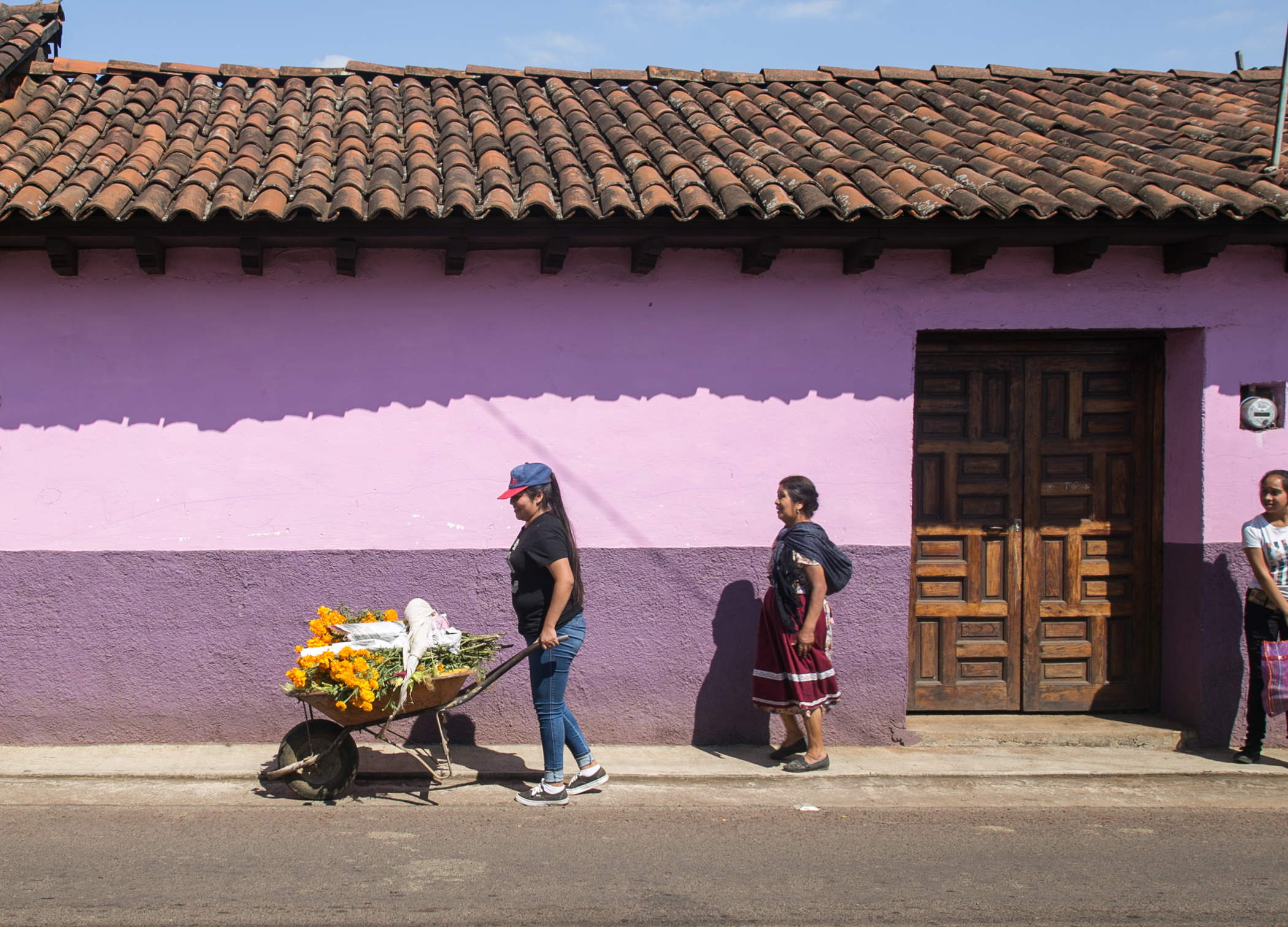  11/1/17 - Karla Cortes, of San Francisco Uricho, leaves her home with a wheelbarrow of marigolds, coffee cans, and candles. Karla, her mother, and sister, take this same walk every year, and will spend the afternoon decorating several of their famil