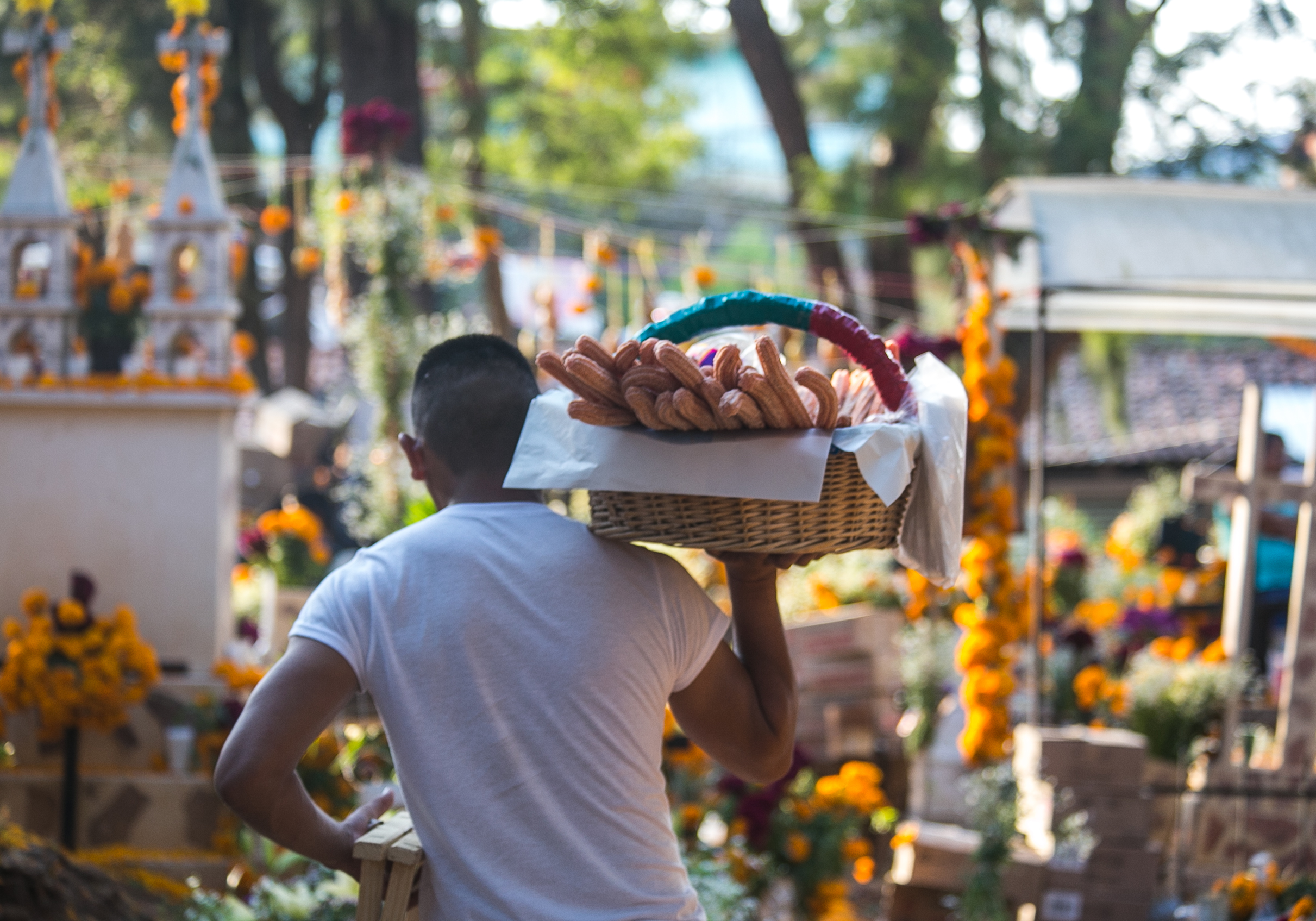  11/1/17 - A vendor walks amidst the graves yelling, "Hot churros! I got churros!"  