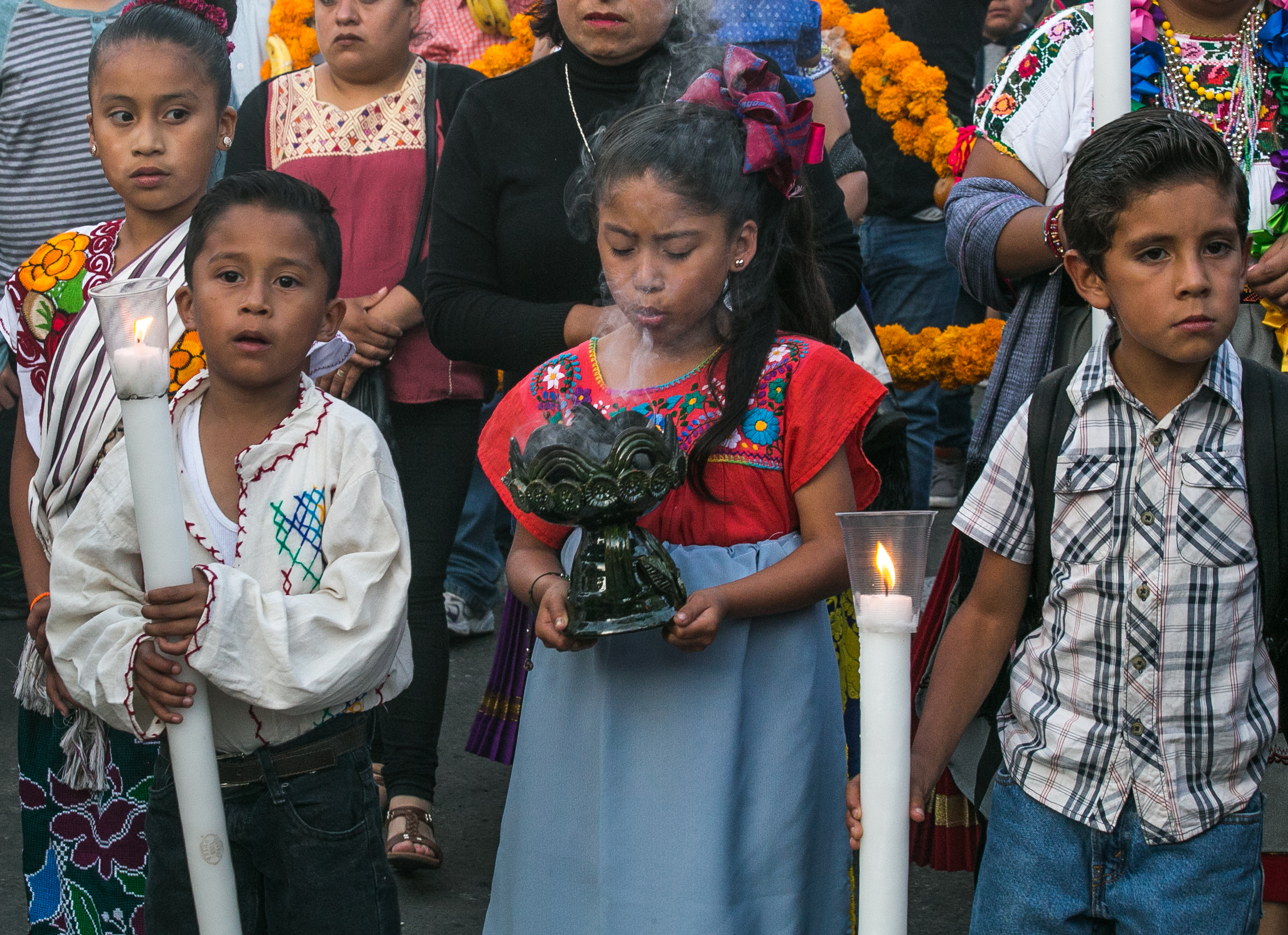  11/1/17 - Children walking with their family to the cemetery hold candles and copal (traditional incense). 