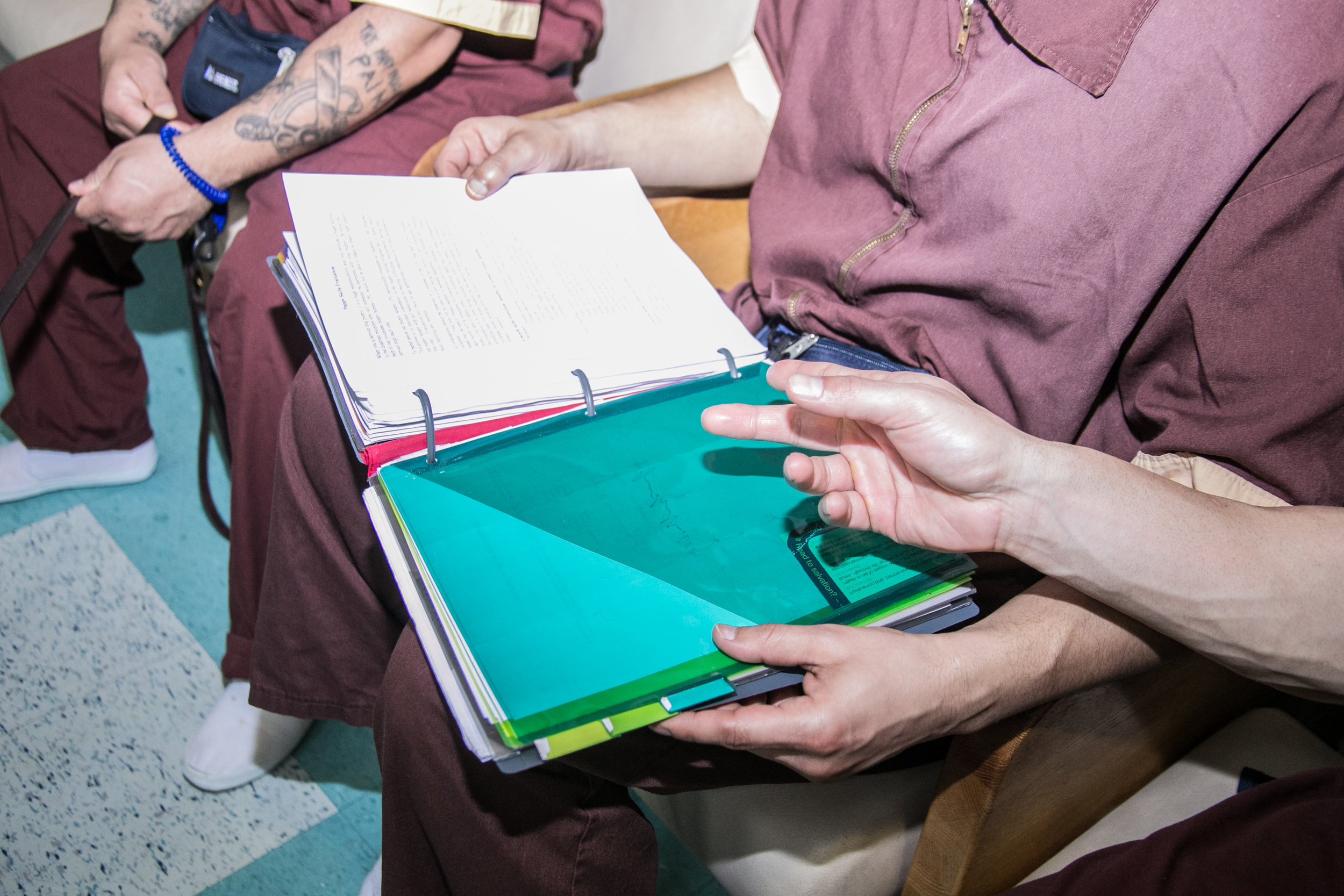  Handlers of the Canine Partners for Life program at SCI Maximum Security Prison  review the day’s training session. Each inmate is given a personalized handbook to manage and record his canine’s progress.  