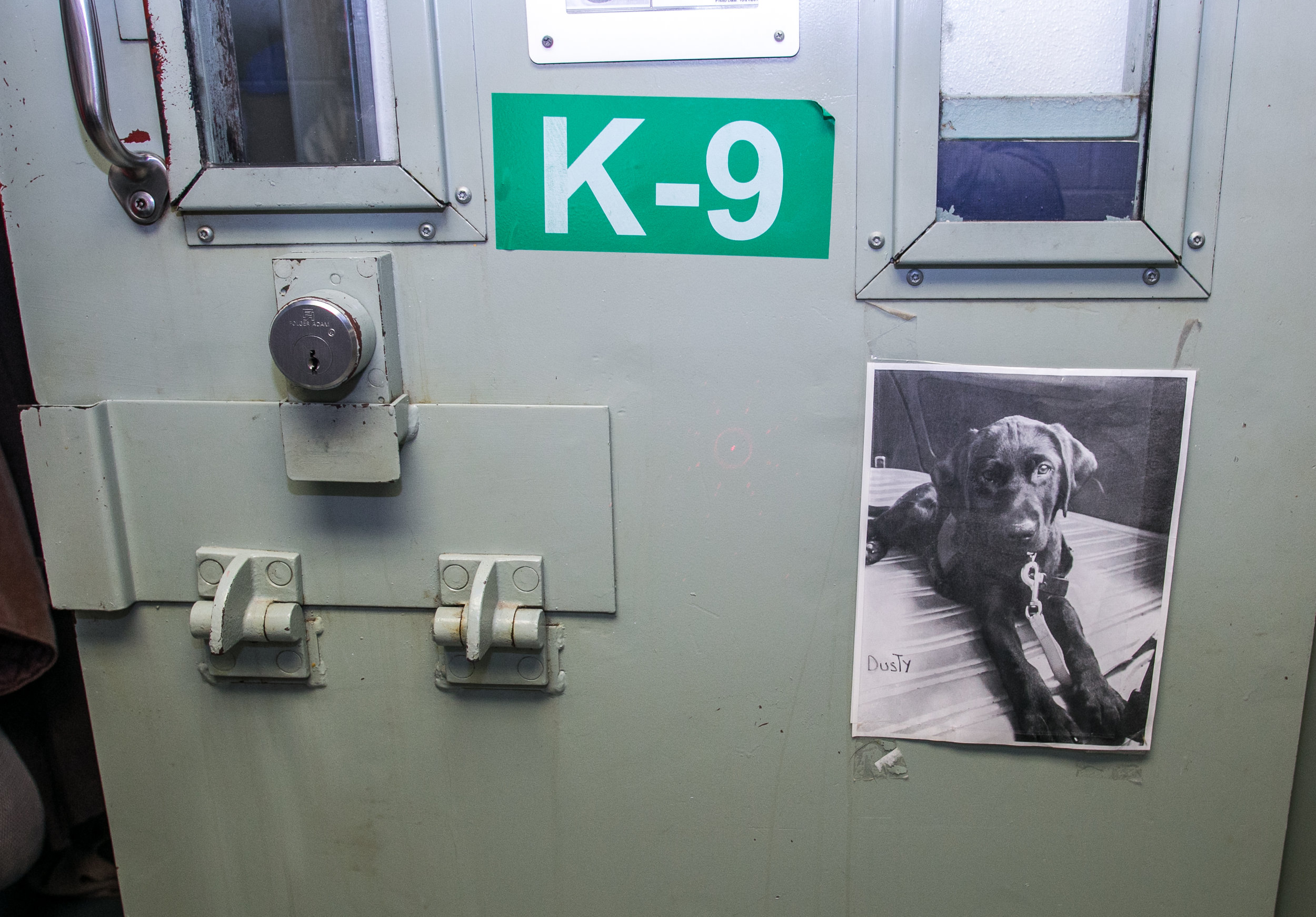  Nike's photo taped to Ralph’s door below a green K-9 designation sign. 