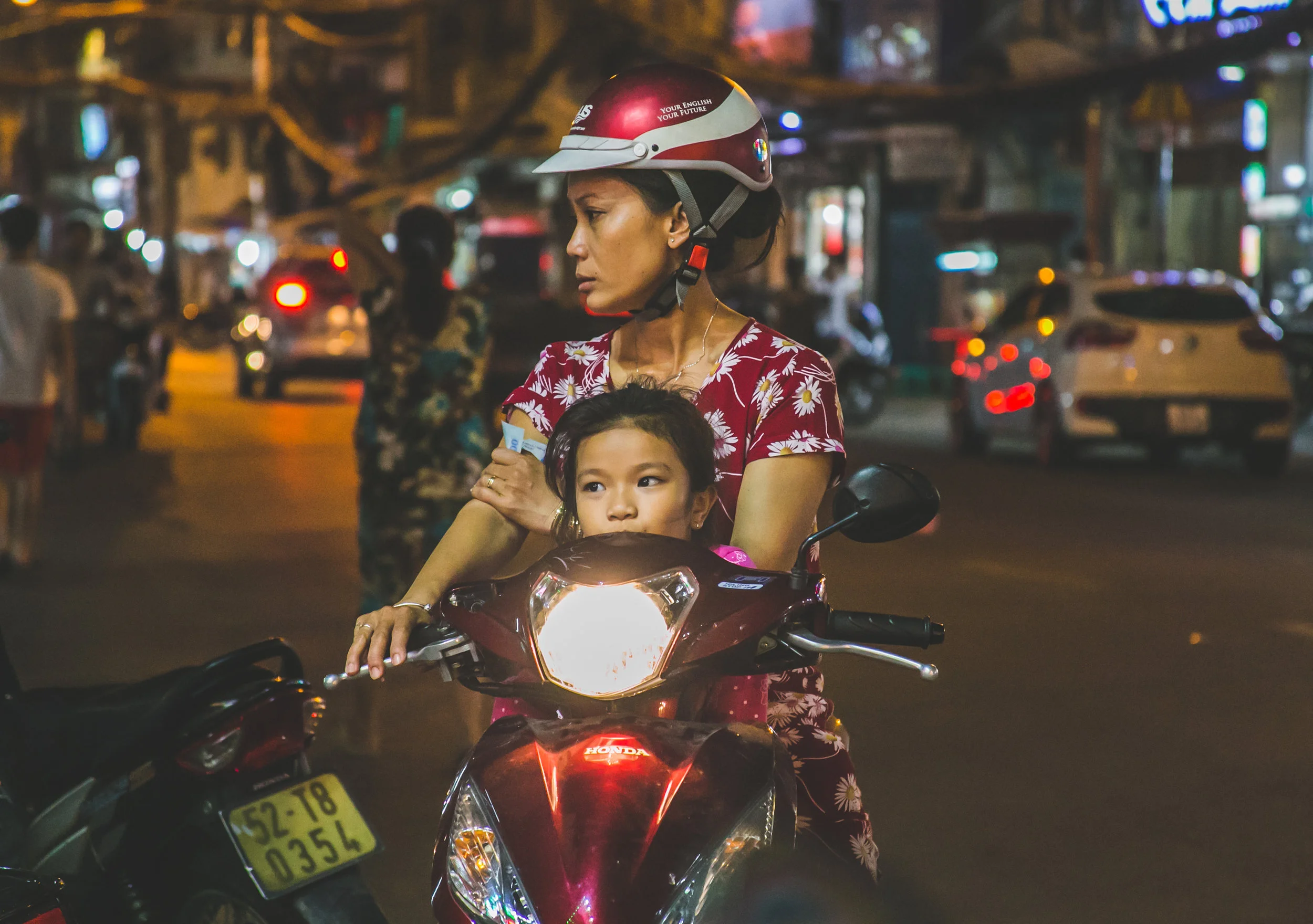 1:23am - A girl rides with her mother on a motorcycle throughout the streets of Ho Chi Minh City, Vietnam. Ho Chi Minh now boasts over 7.43 million active motorcycles on its streets. Traffic accidents remain one of the highest causes of death in Vietnam - 30 times the number of people killed by pandemic diseases. In 2015 - 702 people were killed and 3,302 injured.