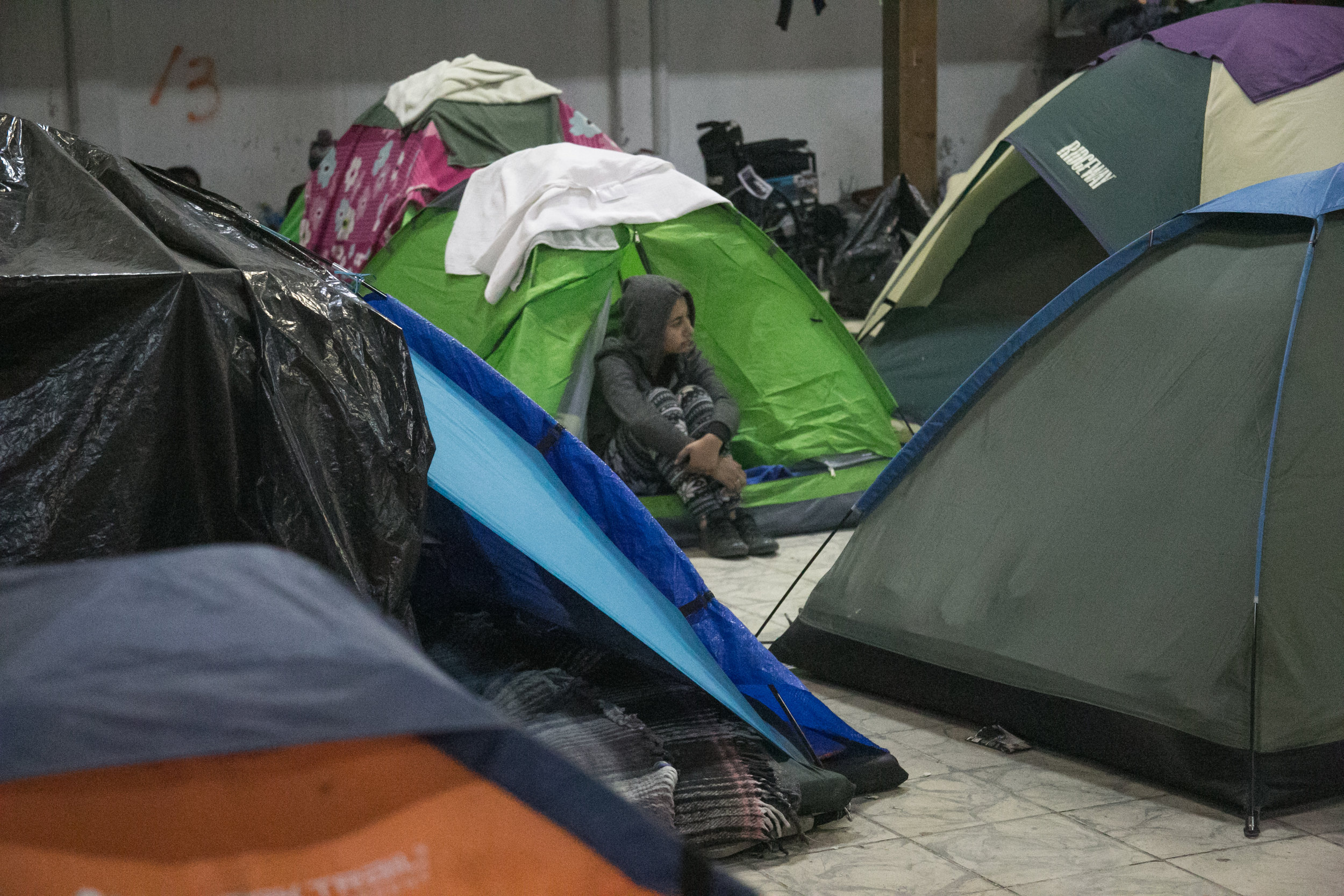  A child sits amidst the hundreds of tents packed into the Barretal compound on the outskirts of Tijuana, Mexico. The Mexican government relocated over 2,000 refugees to this facility after the first camp in Central Tijuana was closed due to intense 