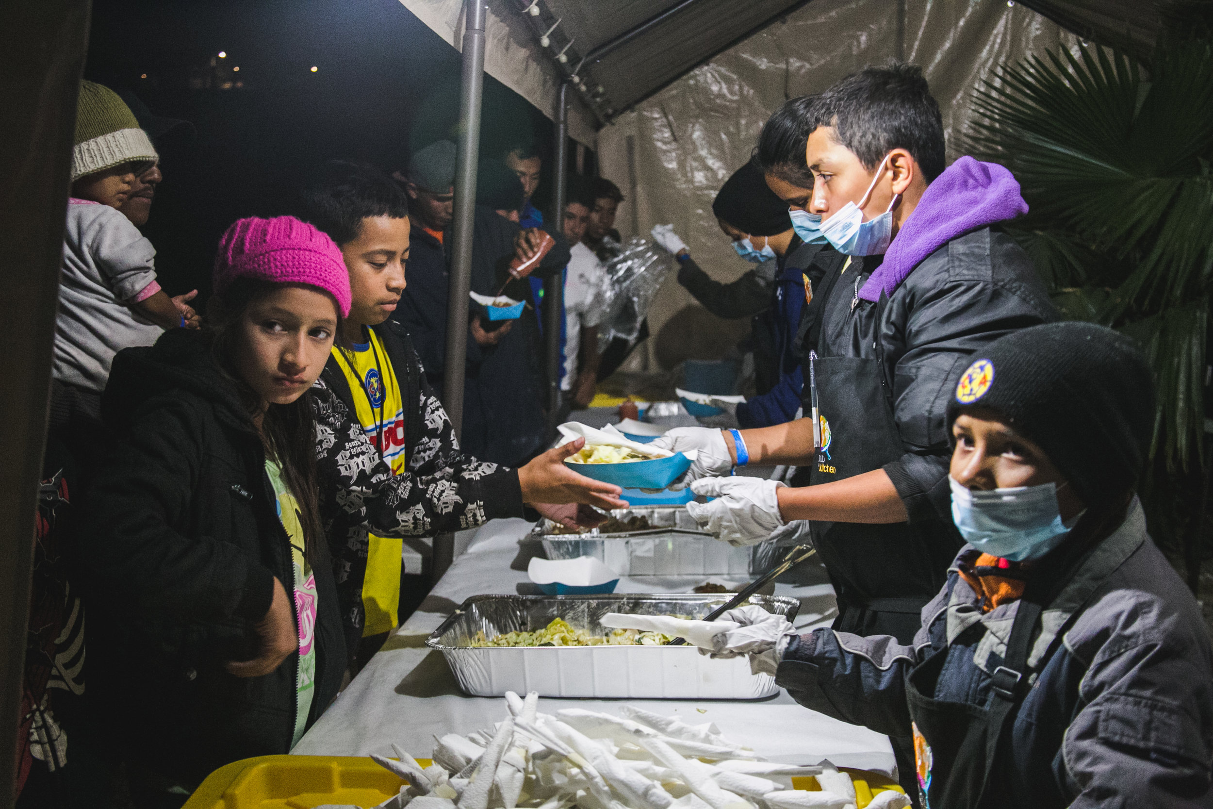  Volunteers serve dinner to over 1,500 refugees. Each day, 5-6 children from the camp would assist World Central Kitchen with serving lunch. The goal of the program surrounds creating a sustainable refugee-operated kitchen in Tijuana to serve for mon