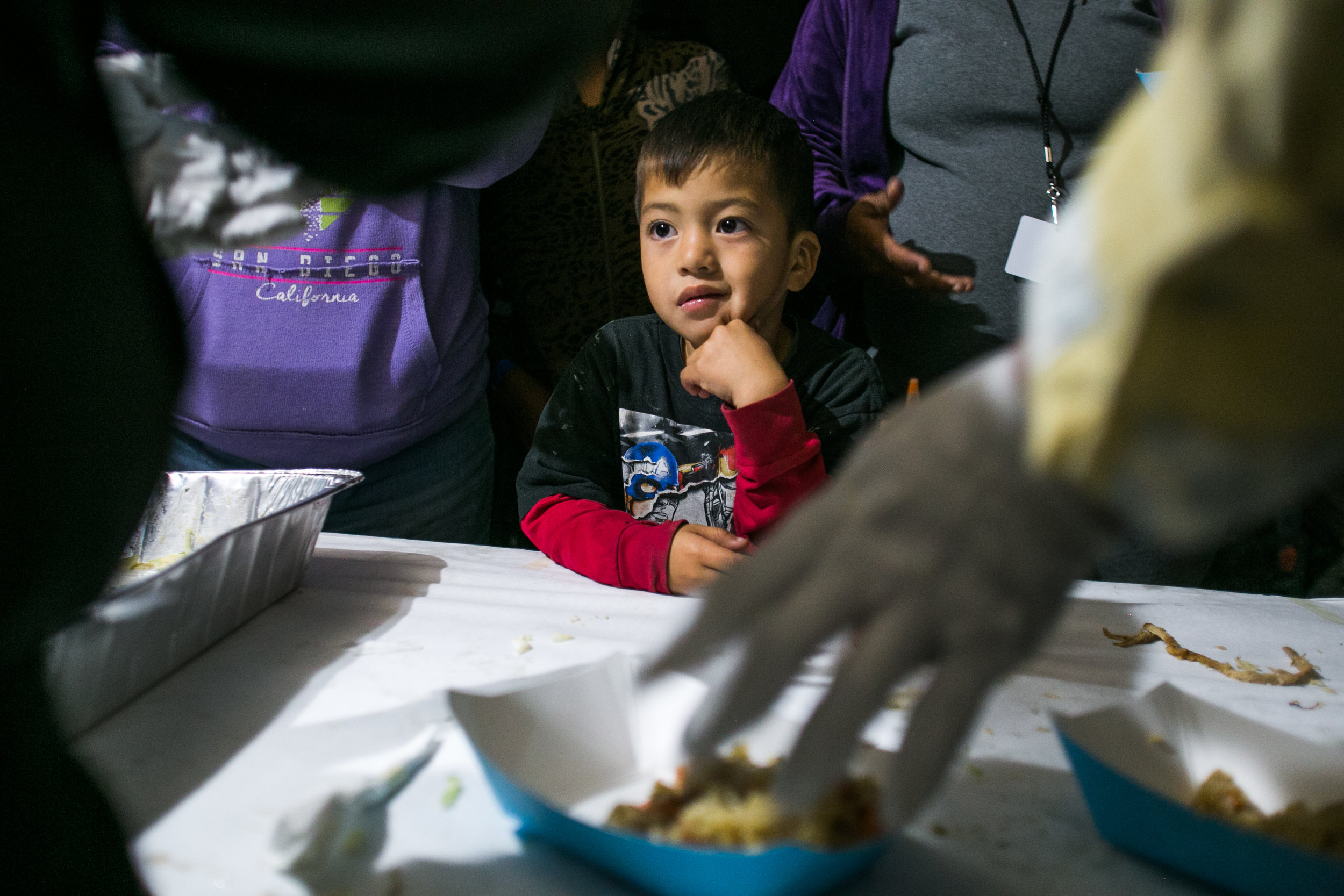  A child watches on as volunteers from World Central Kitchen prepare dinner at the Barretal refugee camp. 