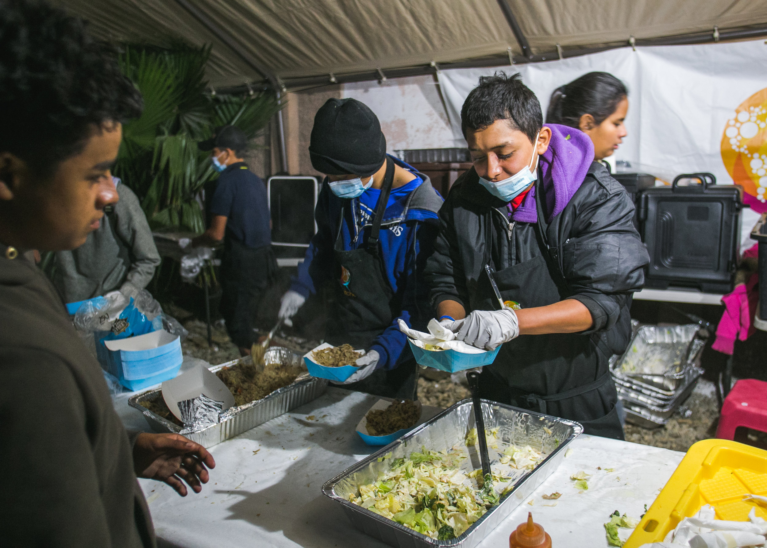  A volunteer serves dinner to over 1,500 refugees at the Barretal refugee compound. Each day, 5-6 children from the camp would assist World Central Kitchen with serving lunch. The goal of the program surrounds creating a sustainable refugee-operated 