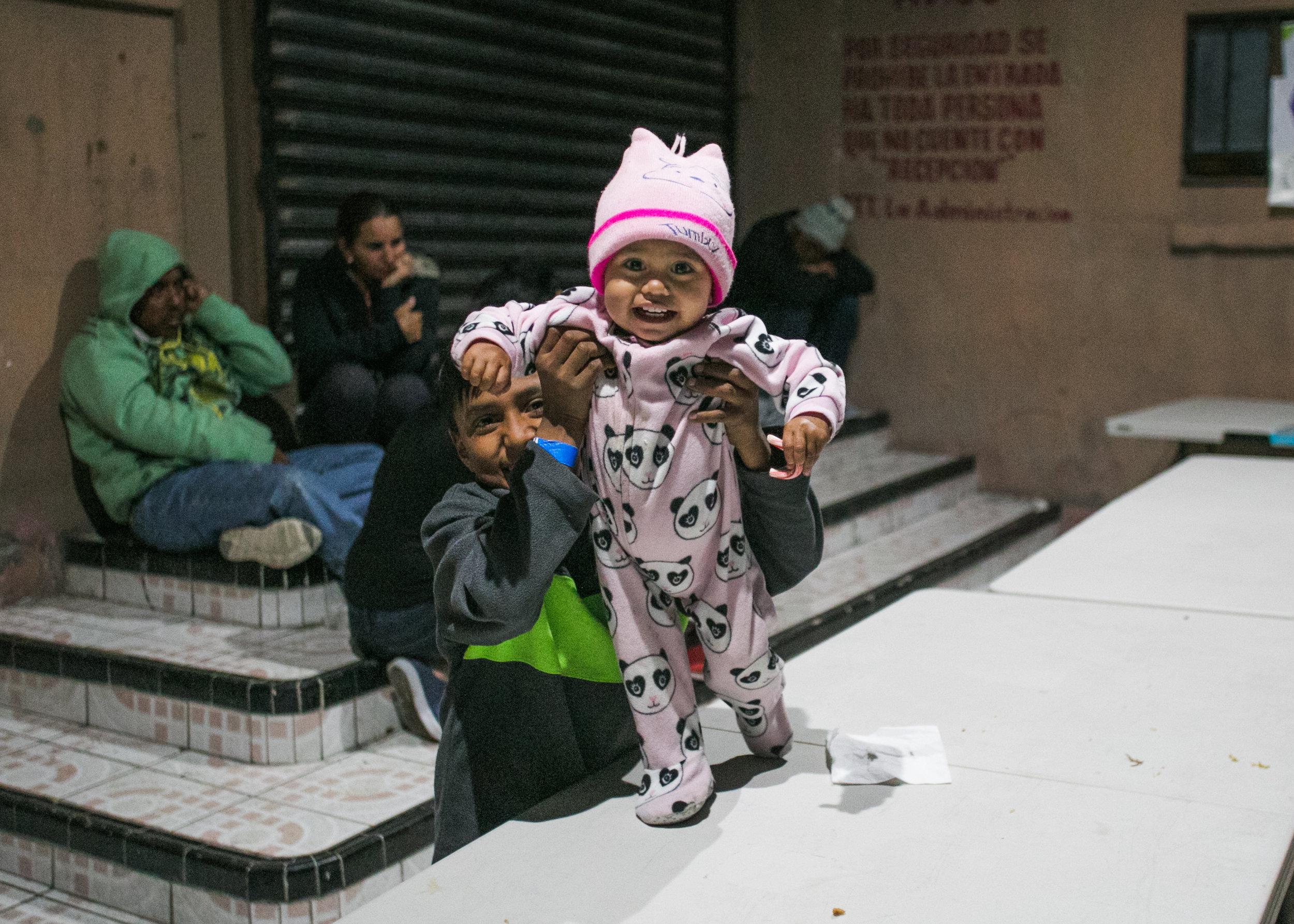  Siblings play on the dinner tables of Barretal refugee camp in Tijuana, Mexico. 