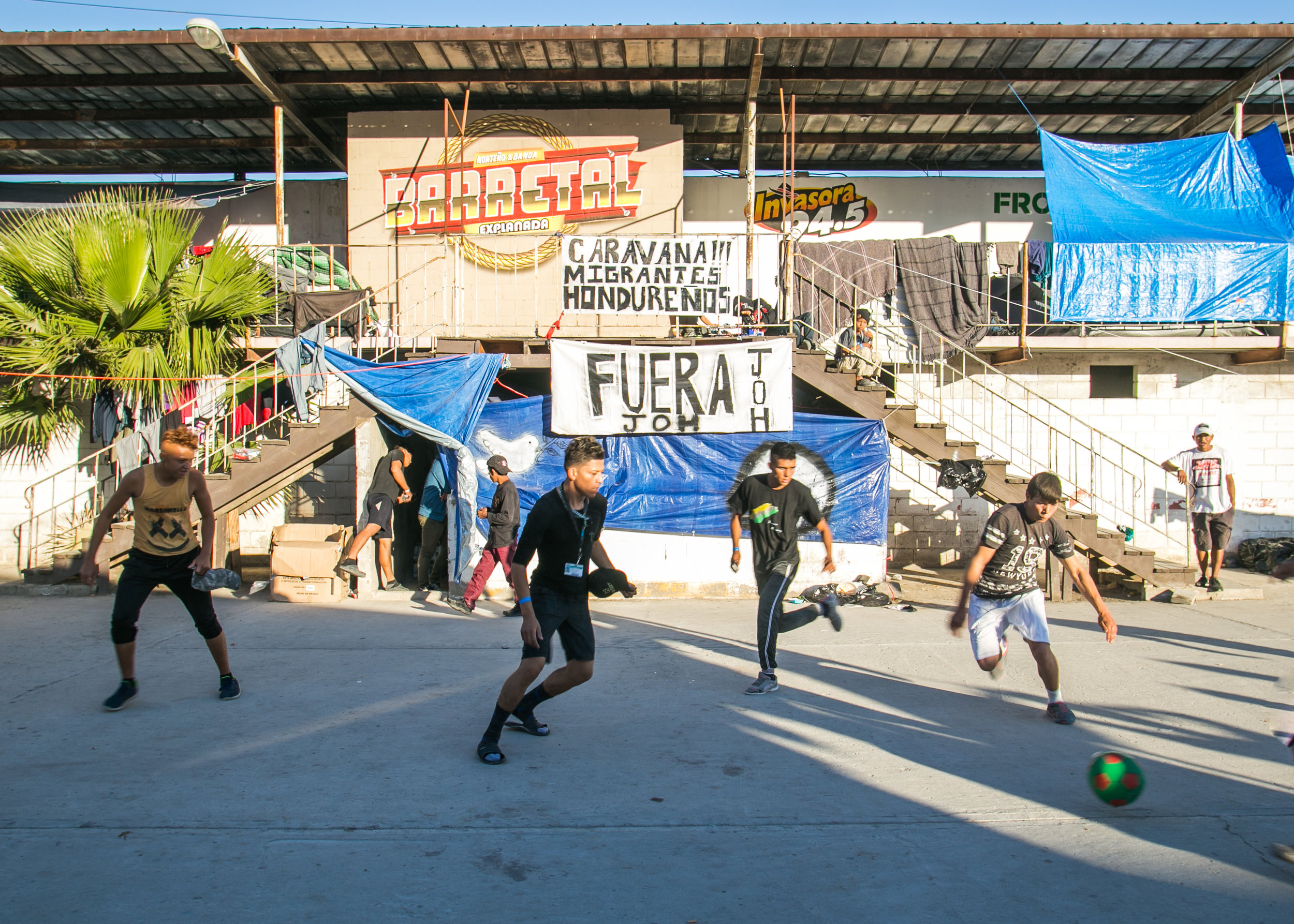  Refugees play soccer in the single male section of the Barretal border camp located just outside of Tijuana, Mexico. 