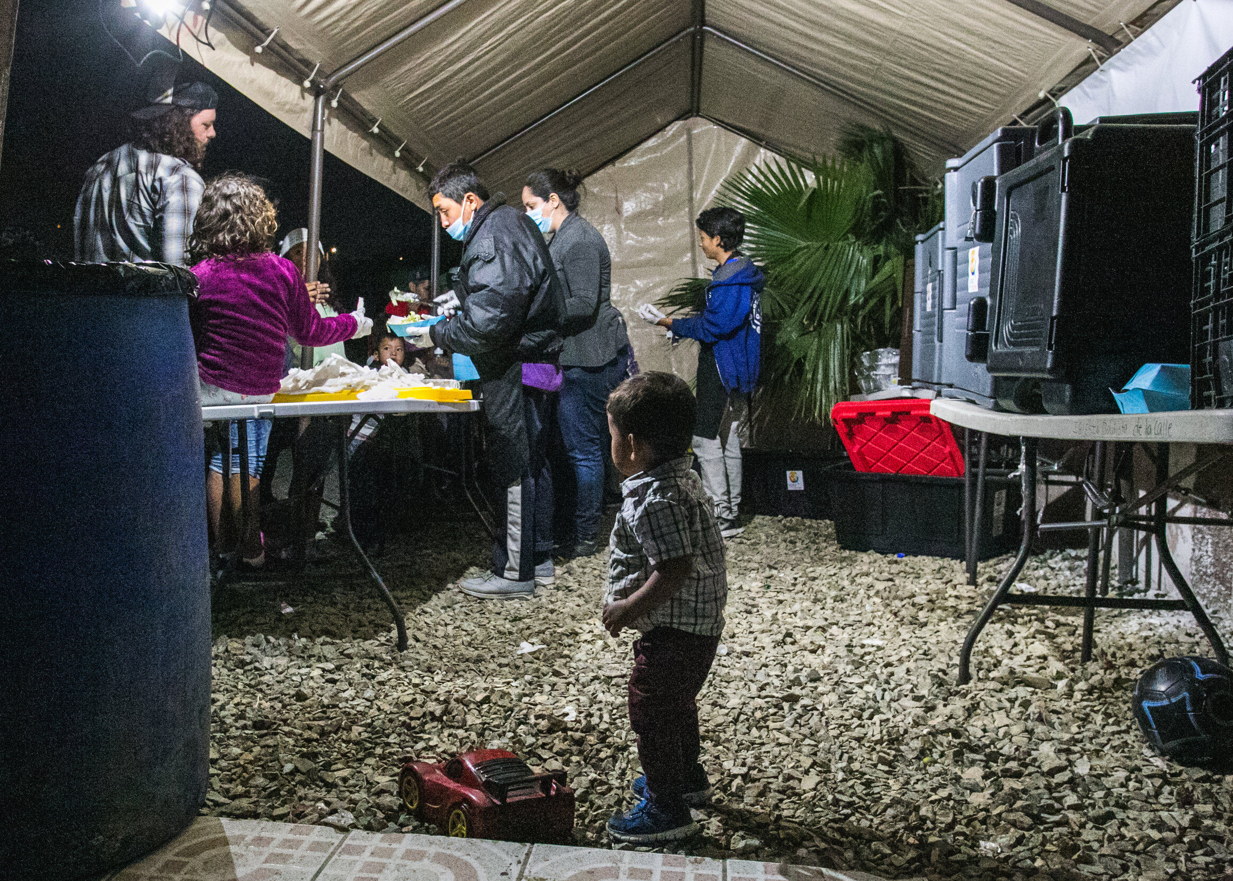  A cild watches on as volunteers from World Central Kitchen prepare dinner at the Barretal refugee camp in Tijuana, Mexico. 