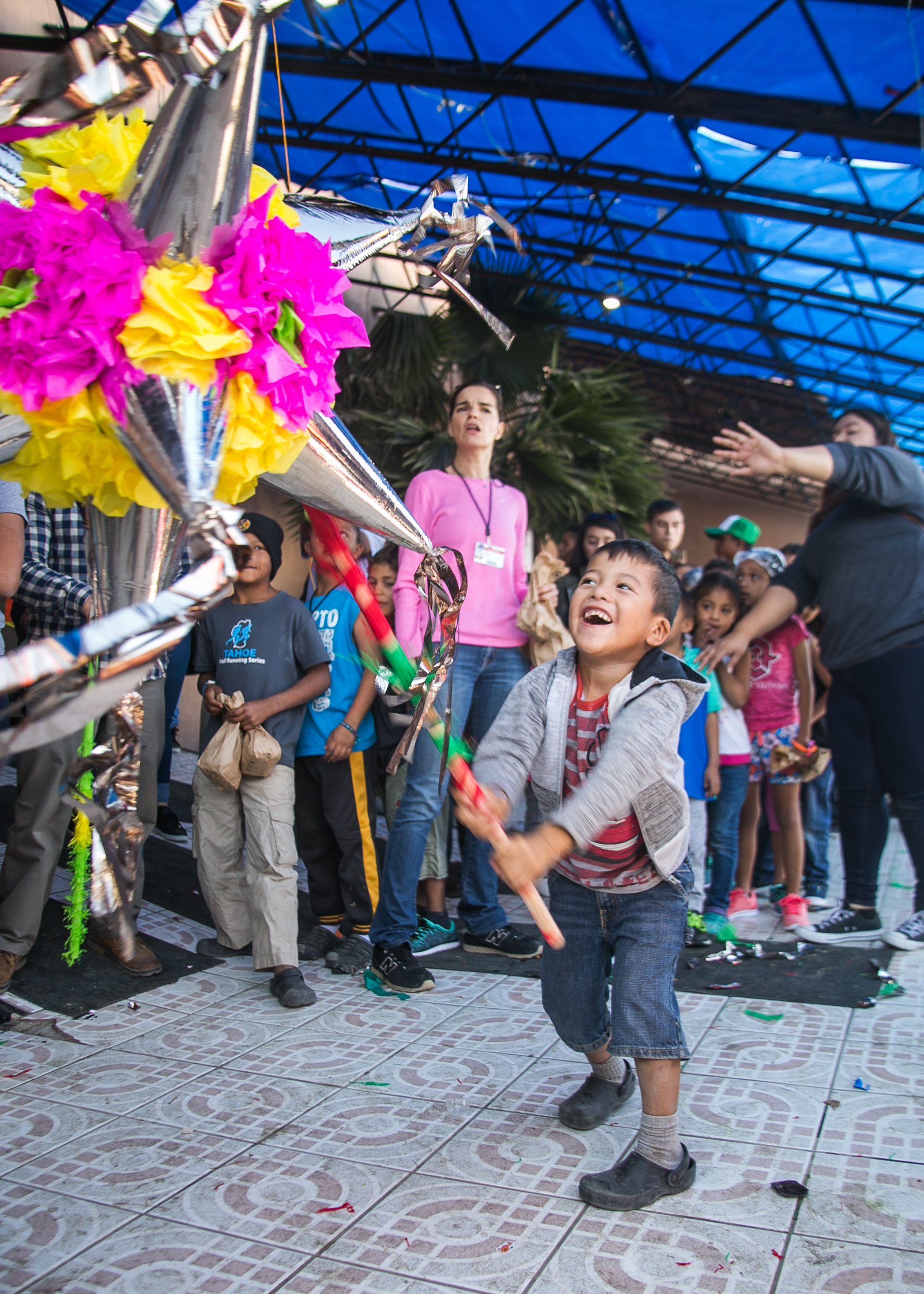  A child strikes a pinnate with joy after six were donated for the many children occupying the Barretal refugee camp in Tijuana. 