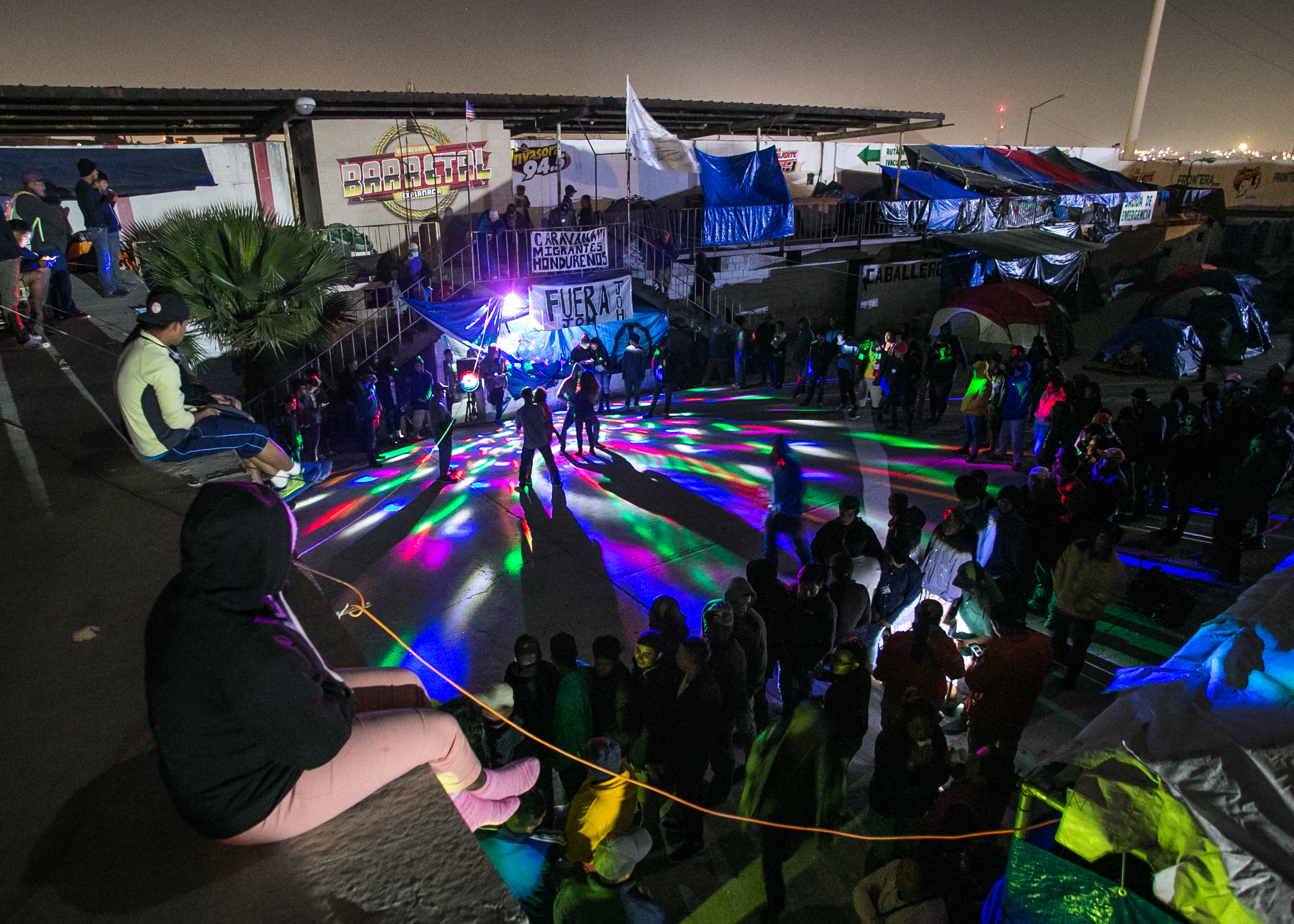  Refugees have a makeshift dance party using a donated speaker + microphone set.  