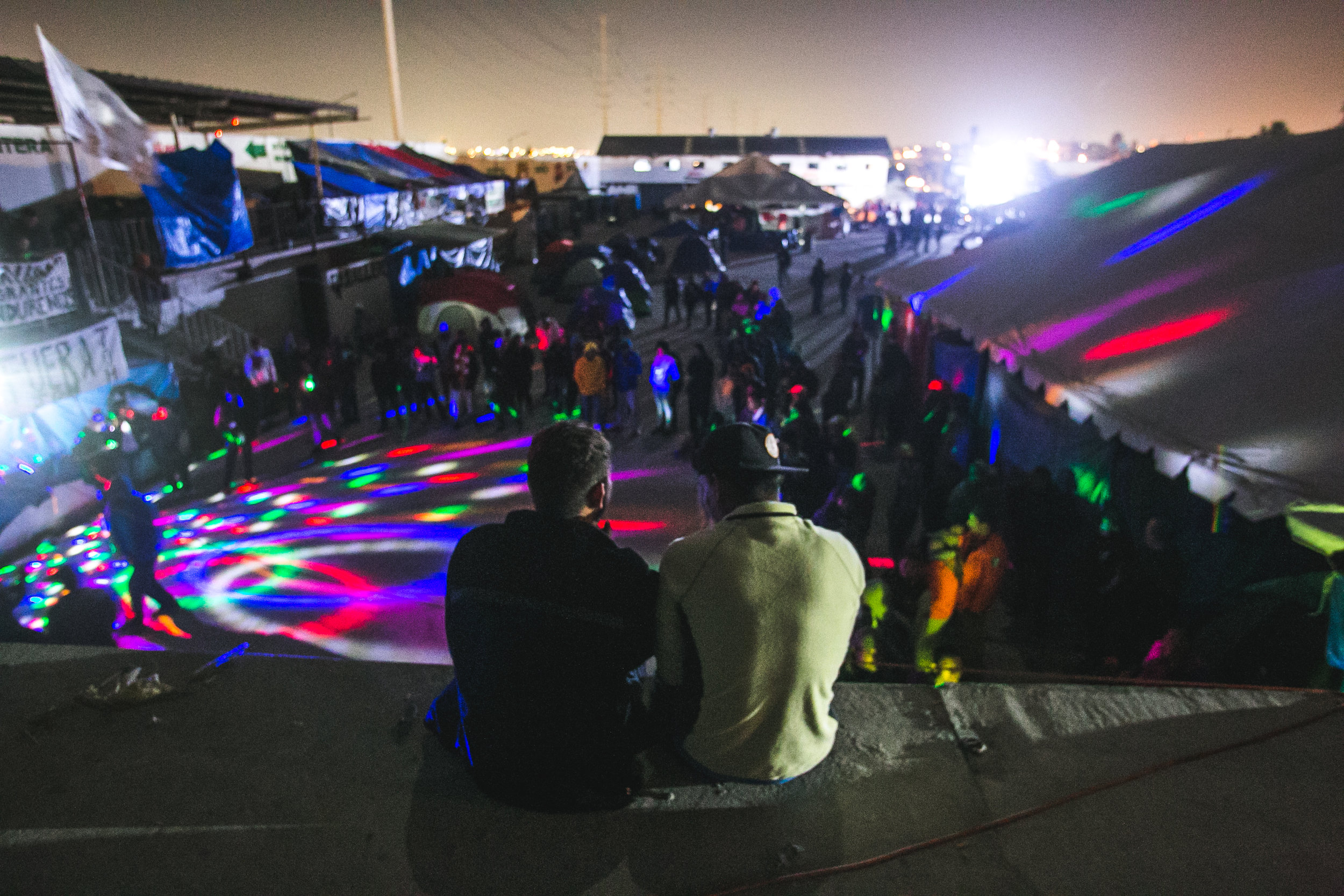  Friends watch on as refugees have a makeshift dance party using a donated speaker and microphone set. 