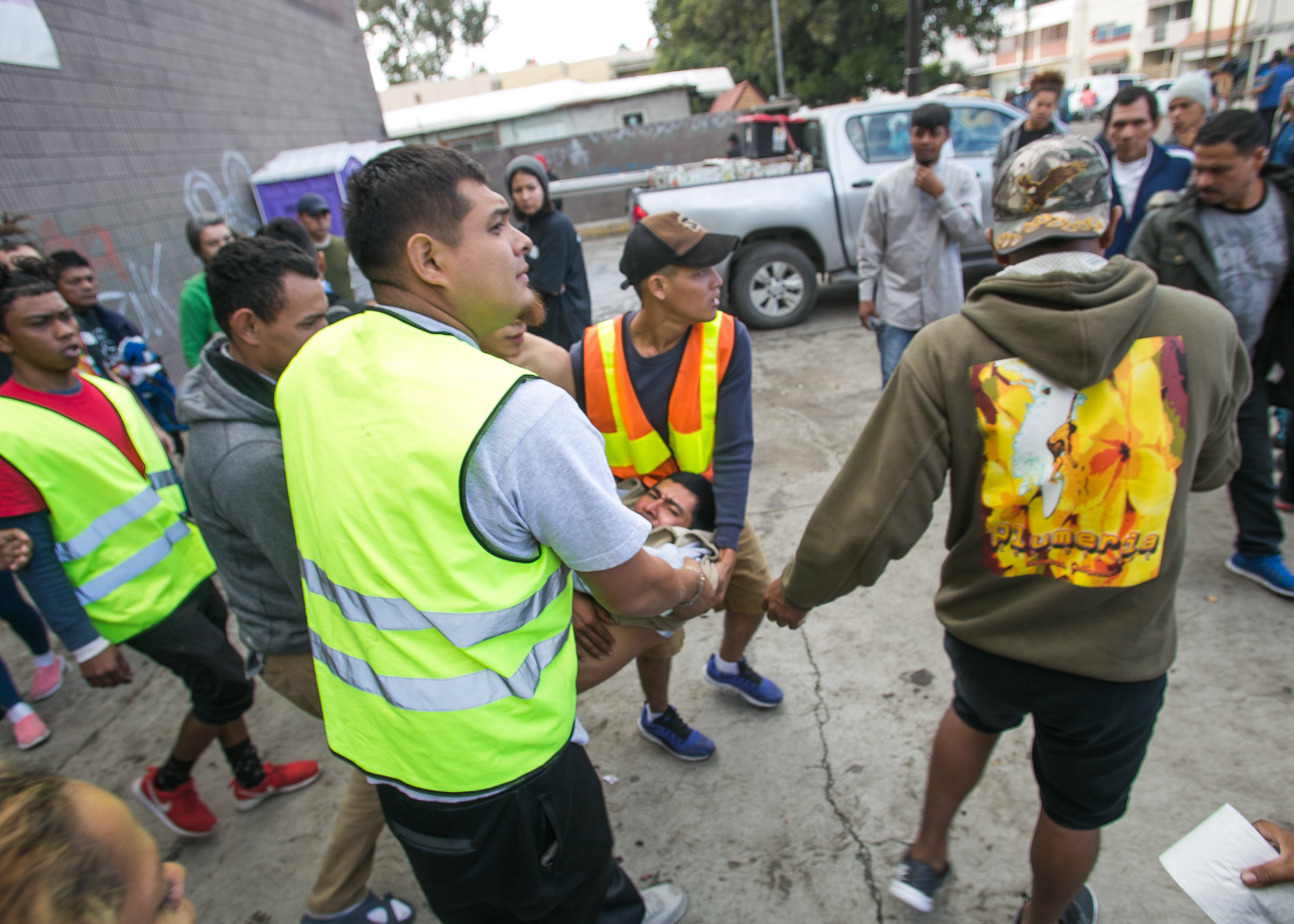  A man is carried out of the El Chinchetta refugee compound in Central Tijuana. He began seizing and vomiting due to a lack of medication according to responders on scene. Medical services were suspended in the facility several days prior in an effor