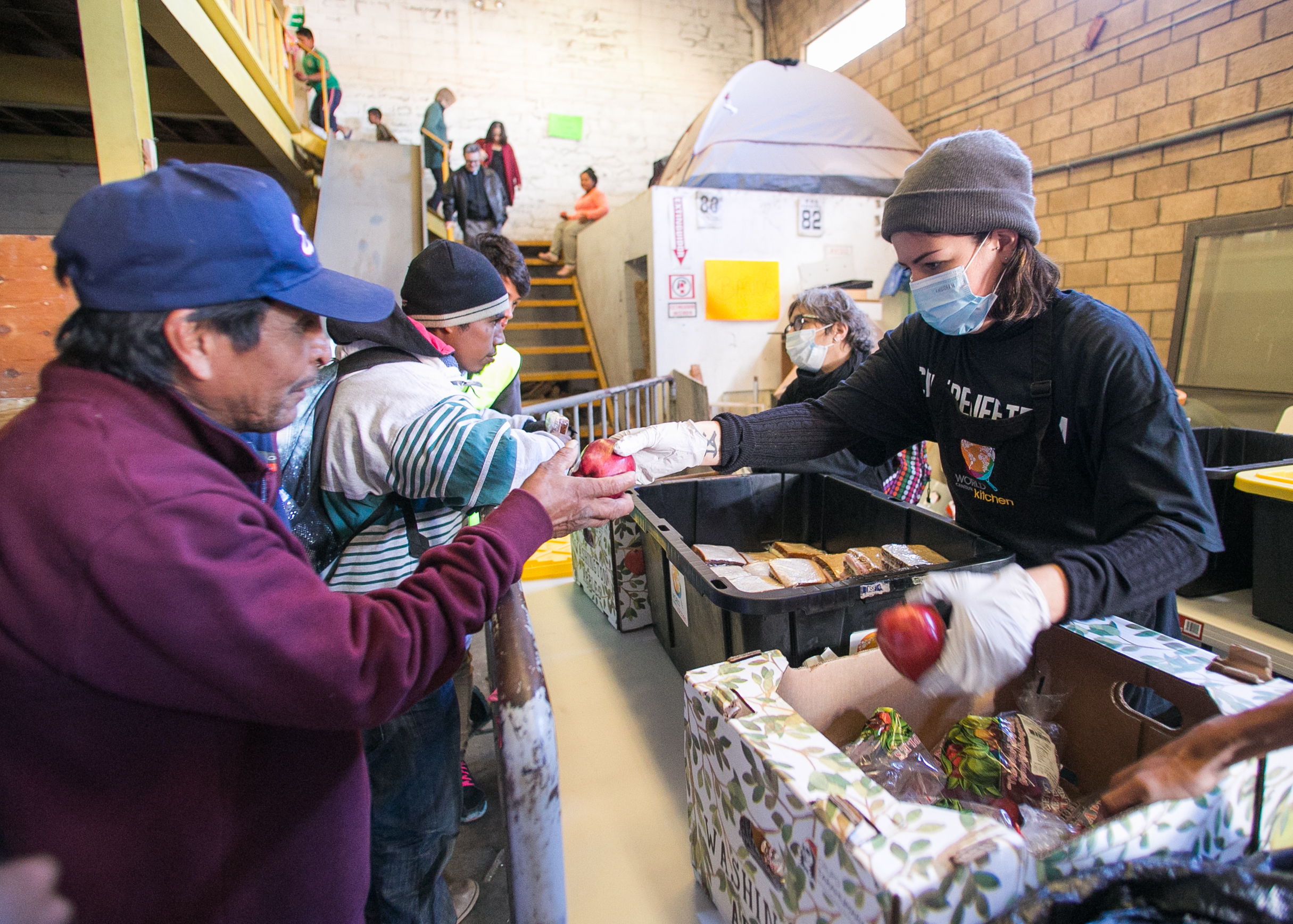  A World Central Kitchen volunteer serves refugees in the El Chinchetta compound located in Central Tijuana.  