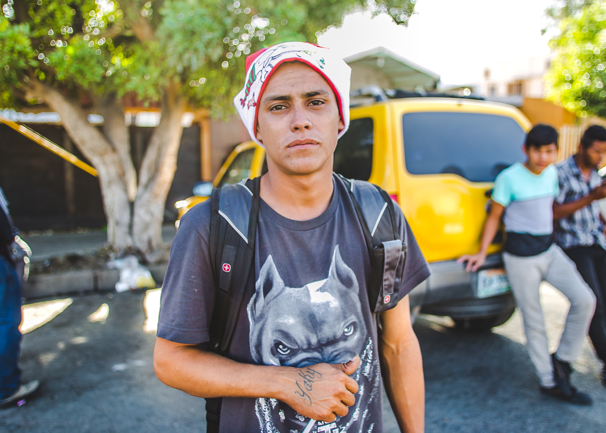  Heraldo Enrique, 19, of Honduras, stands wearing a Santa hat outside the El Chinchetta compound in Central Tijuana. Heraldo left Honduras to escape the pressure of joining a gang. He has been on the road alone for two months 