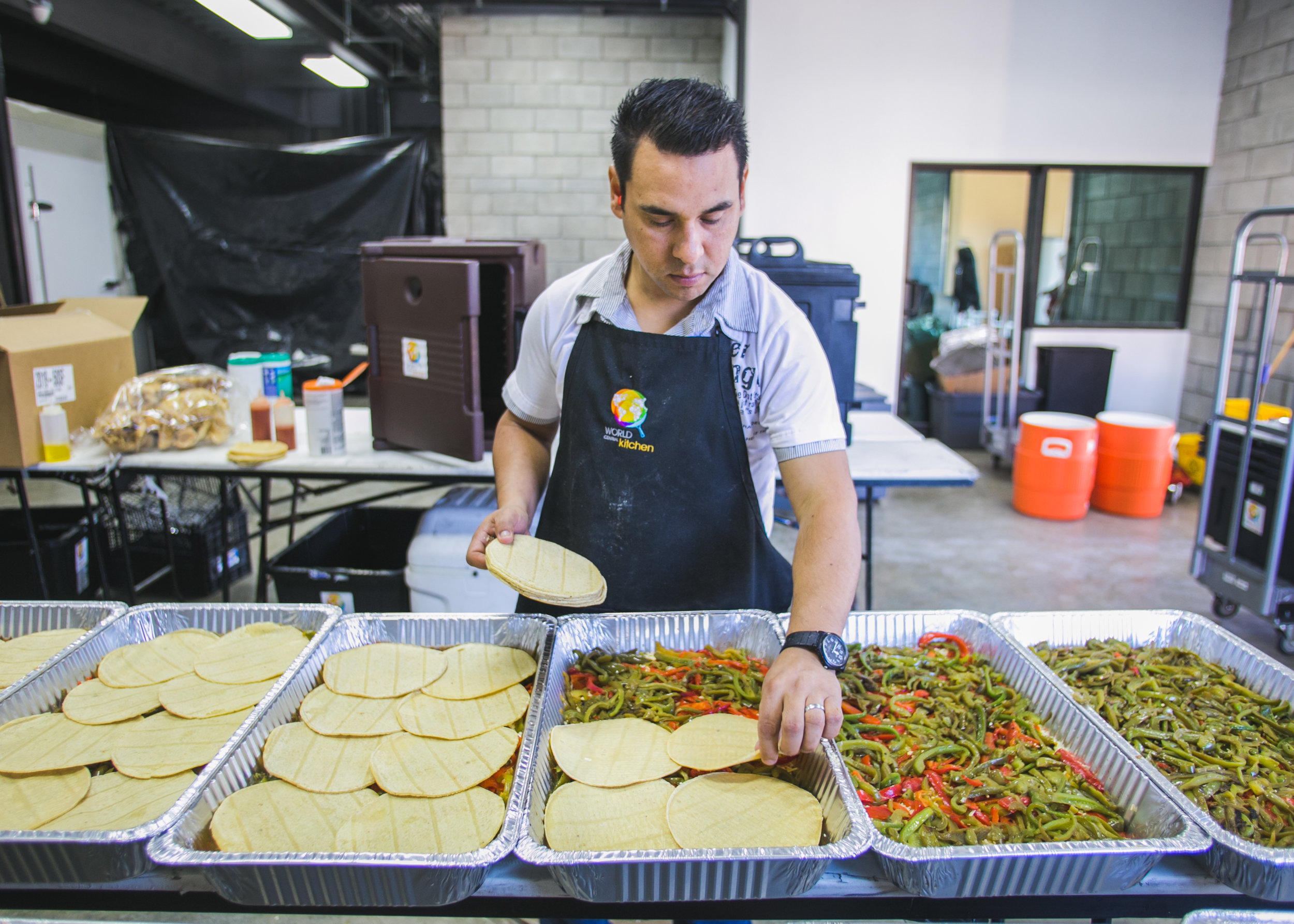  Tijuana pastor and volunteer Leopold Perez helps make dinner for the Barretal refugee camp in the World Central Kitchen Headquarters.  