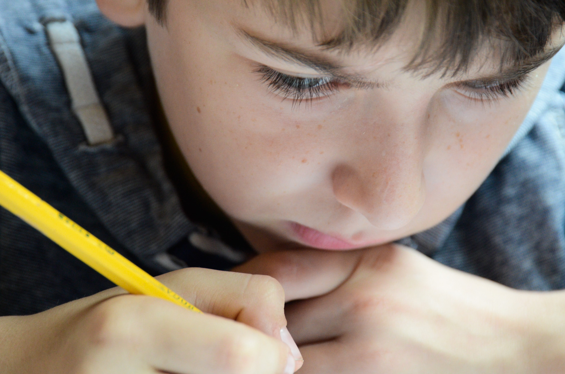 Isaac Deaver concentrates while practicing his handwriting at his home in Berea before going to his grandmother Judy Poulette's home for lessons.