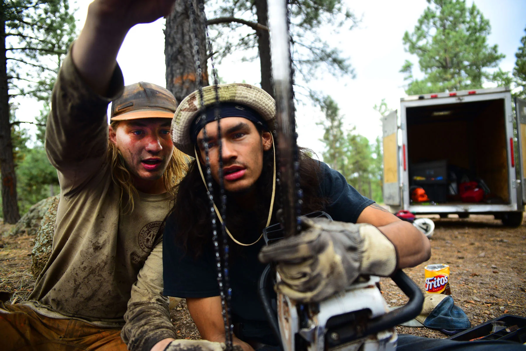 Assistant crew leader, Jake Groth shows crew member, Drake Bentley-Brown how to see the difference between two different chainsaw teeth types. 