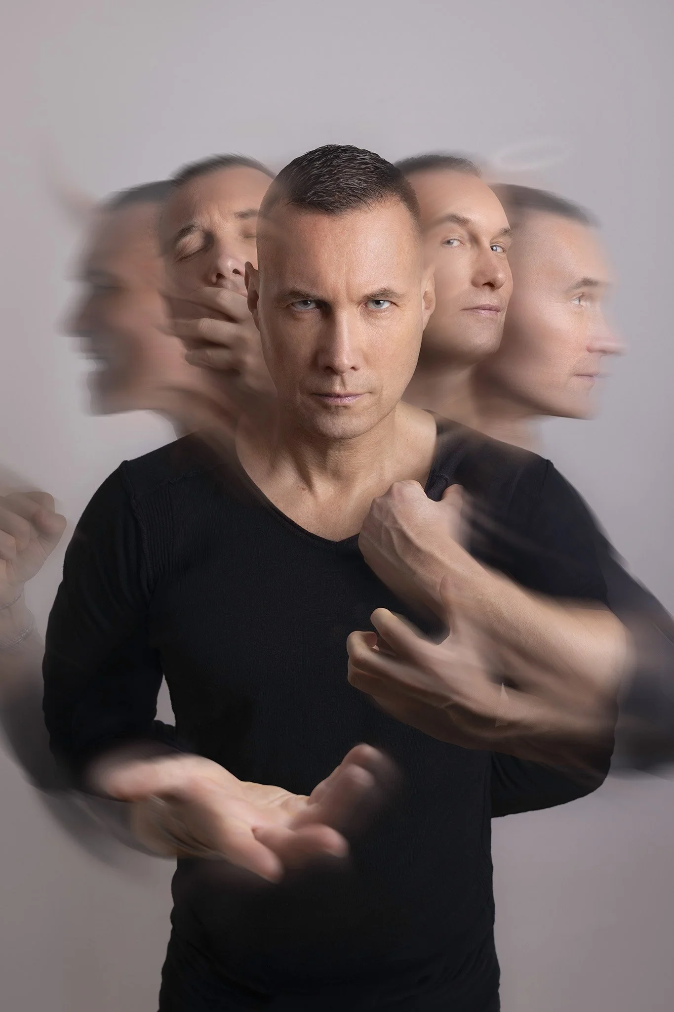 Jeune homme avec plusieurs images floues de sa tête en mouvement, exprimant différentes émotions, fond gris clair.