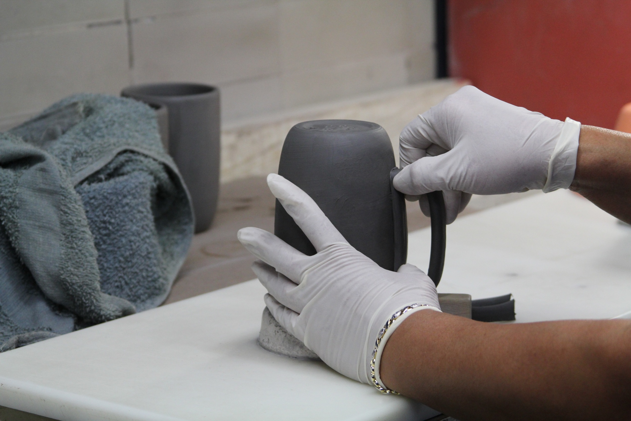 While the handle is still soft and malleable, it's scored onto the mug base. 