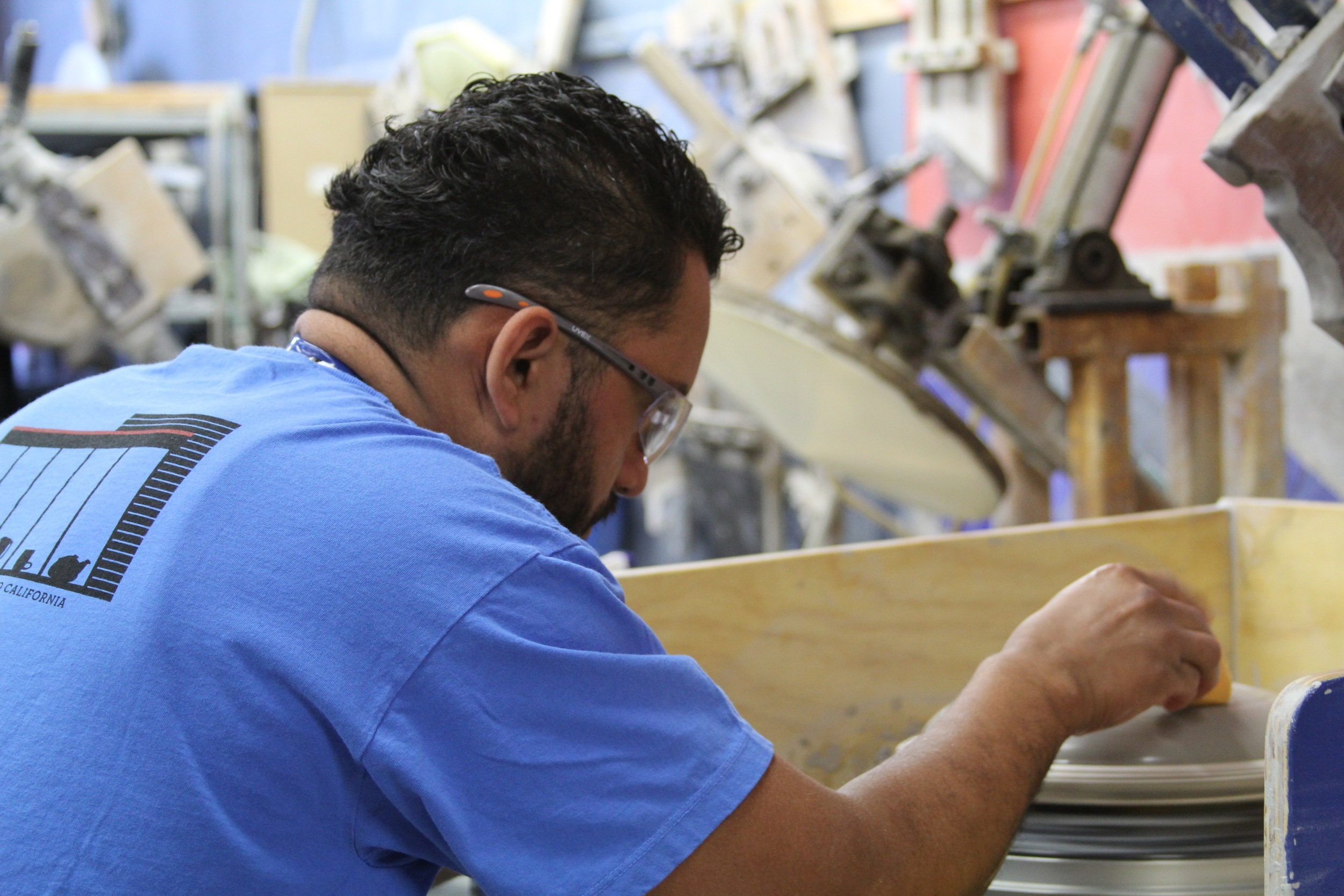 Here, a craftsman hand-jiggers the lid of a clay pot. As most of the work here is done by machine, this is the closest thing the factory does to ceramic "throwing." Casserole lids like the one being made here do require throwing skills, because the knobs on the lids are actually made by hand.