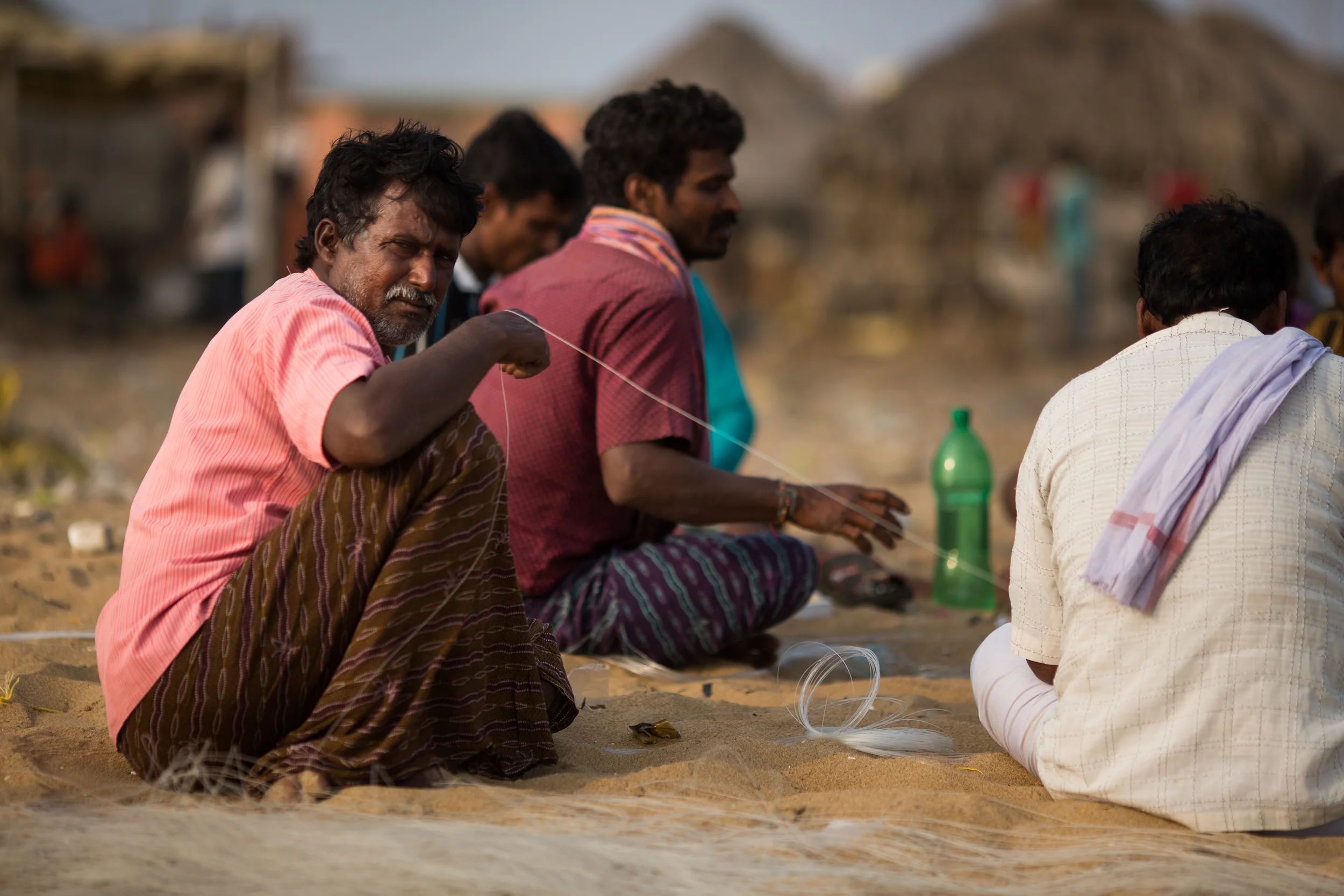 A father returns home. He has enough rupees to provide dinner and perhaps a pair of shoes for his son.