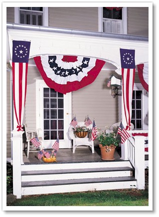 A Large Pleated Full Fan , two Colonial Style Pulldowns and Verona Brand stick flags decorate this porch