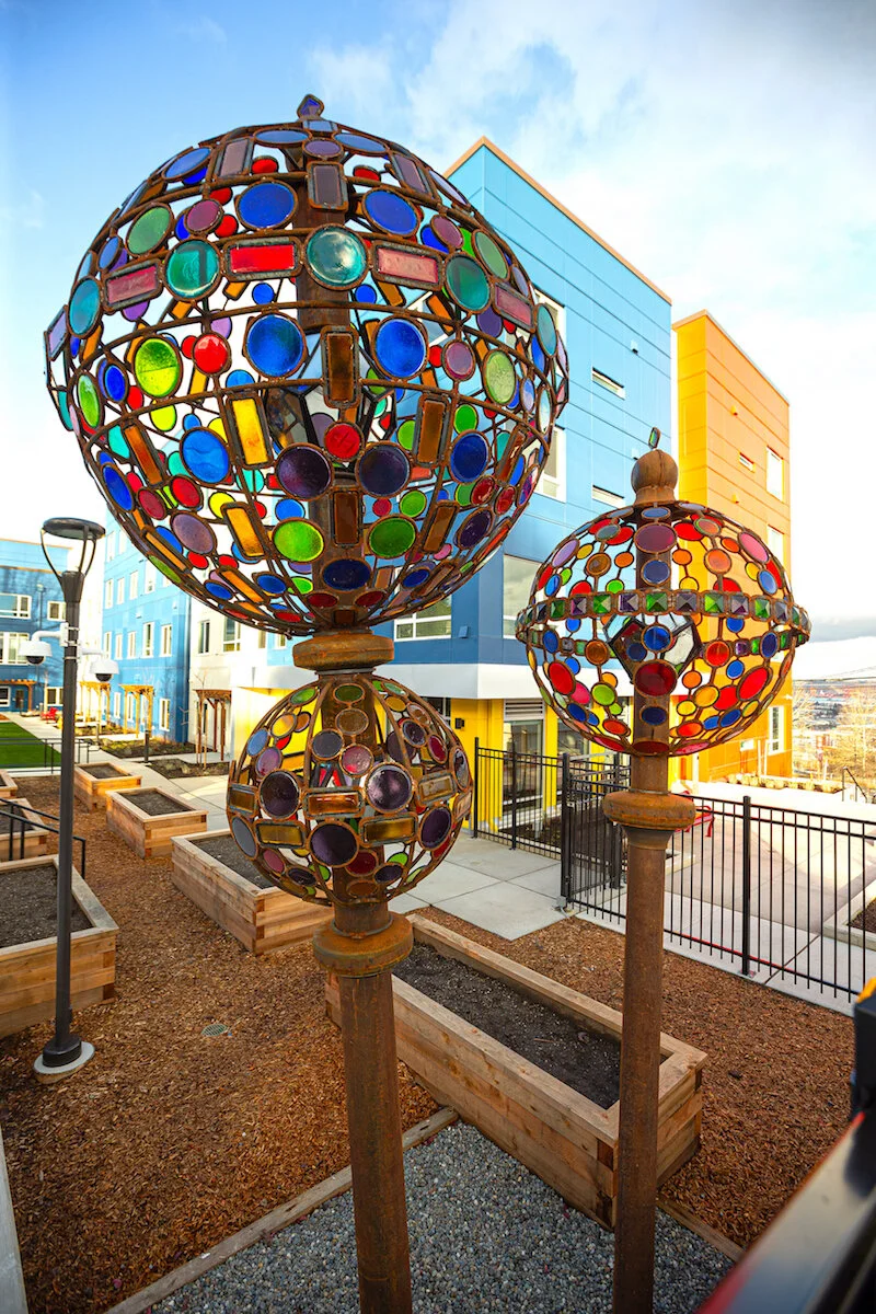  Standing approximately 18 feet tall, the tallest jewel pin has two stacked globes. The larger is 6’ in diameter, the smaller below it is 3’ diameter. Centered in each sphere is an antiqued mirrored globe, which has a lamp inside on a dusk-to-dawn ti