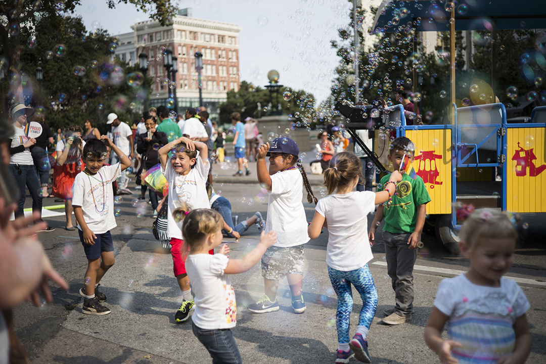 Children playing behind bubble making train.