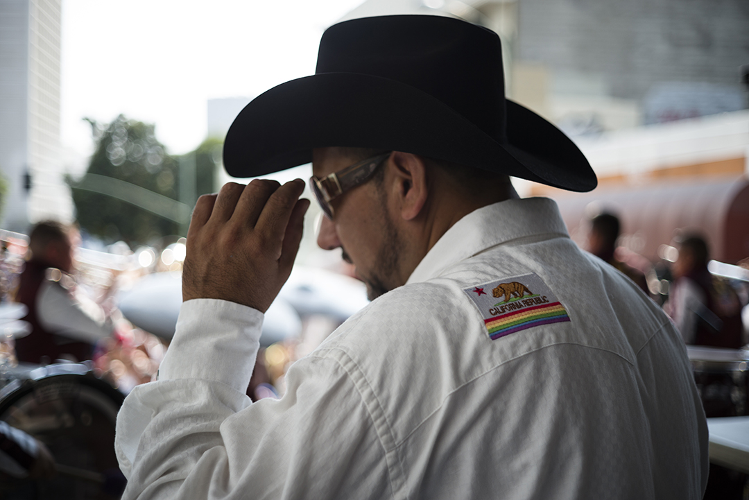 Host on the Latin stage with a California Pride patch.