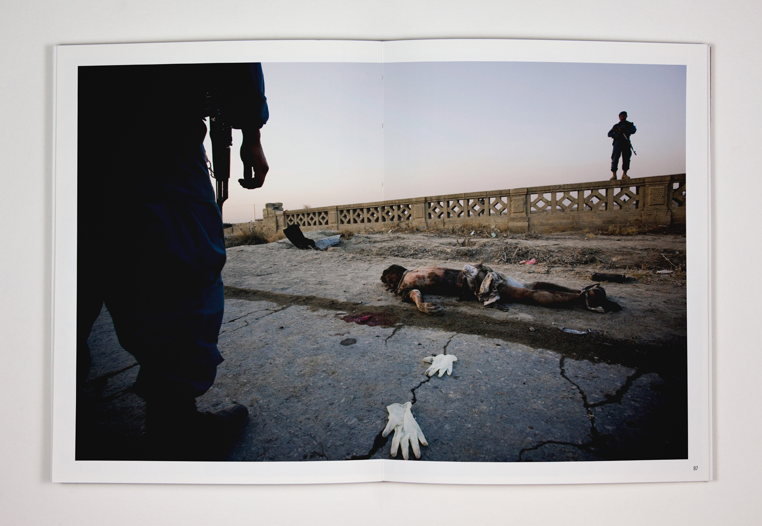 105. The remains of a suspected suicide bomber lie in the street while Afghan policemen look on. The bomber, driving an explosives-filled vehicle, detonated the bomb next to an American military convoy in Kabul. 12 November 2010. Kabul, Afghanistan