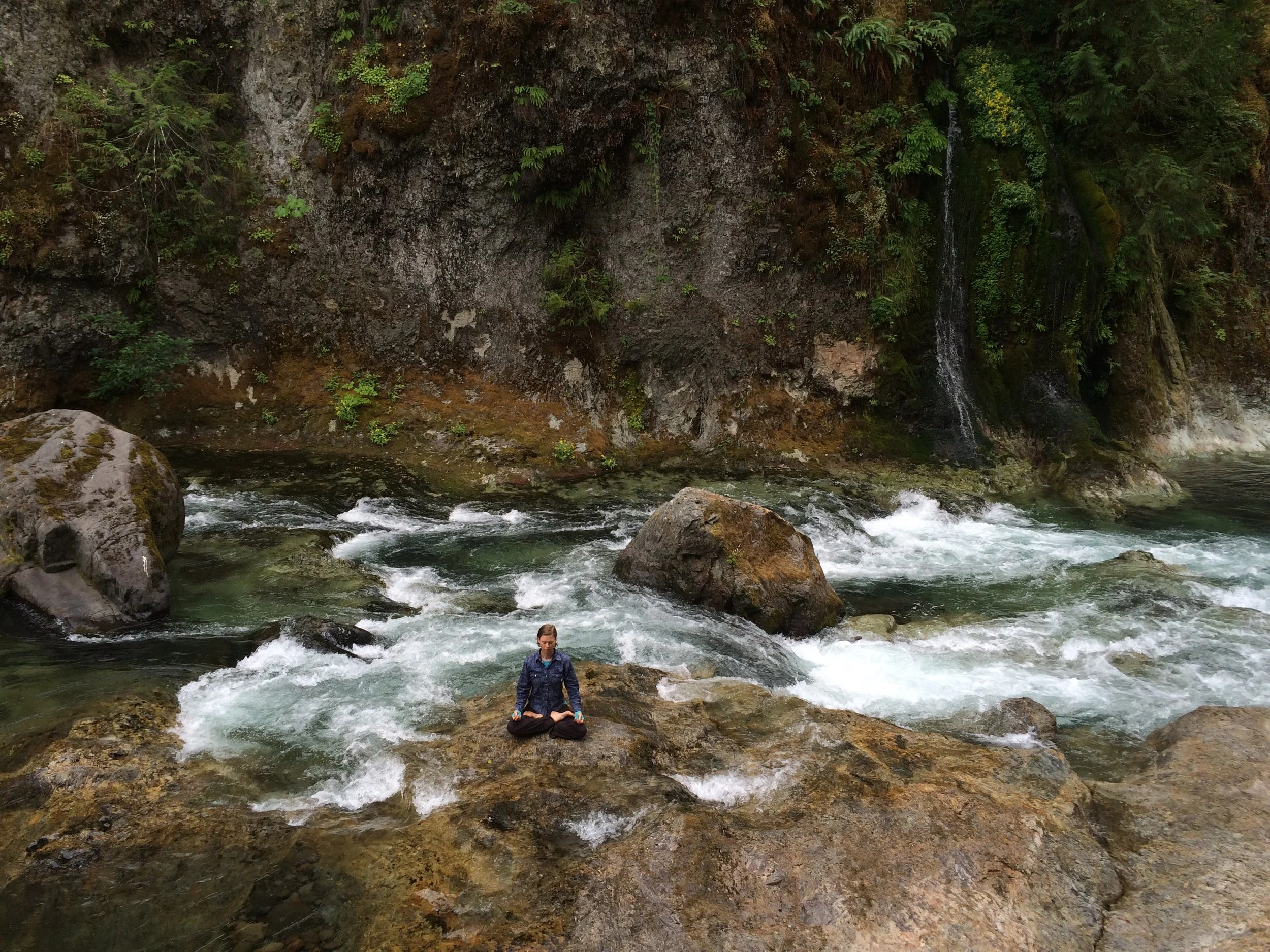 Priti meditating in the gorgeous creek