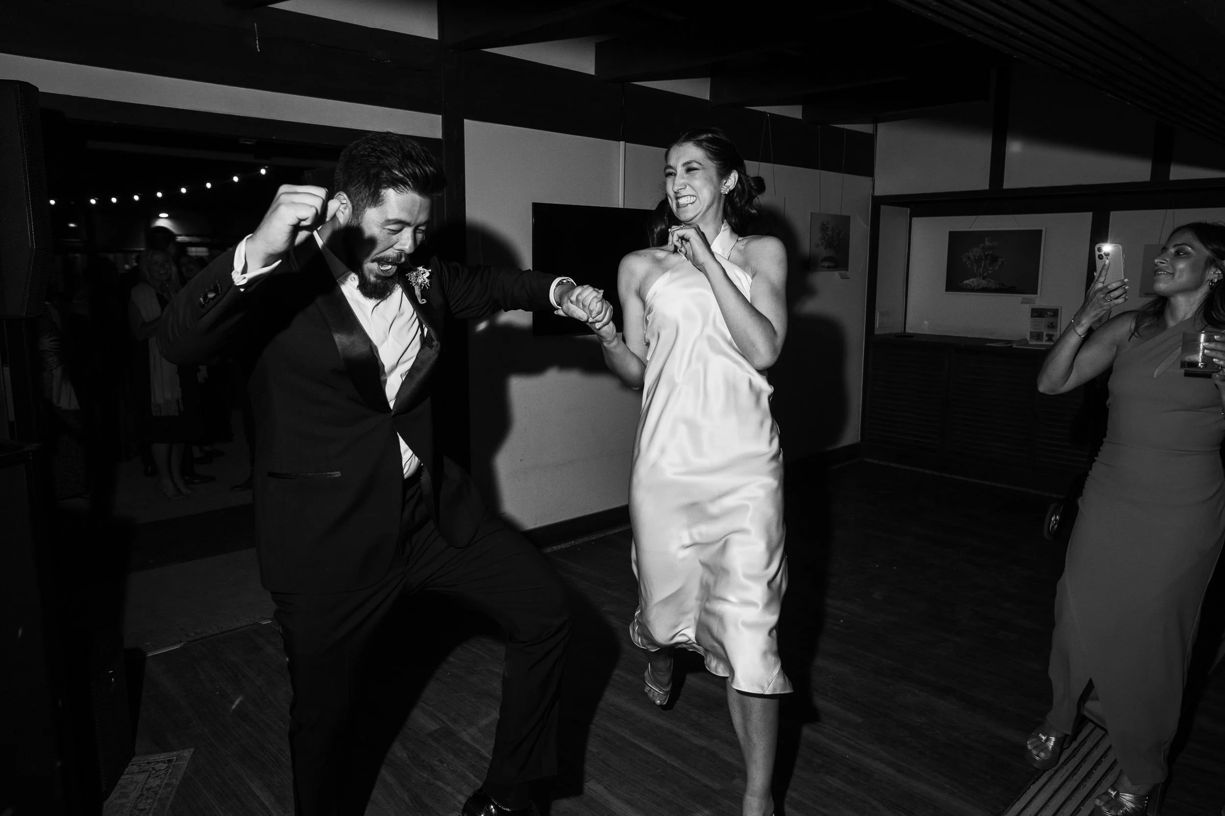 A couple excitedly enters the dance floor at their wedding