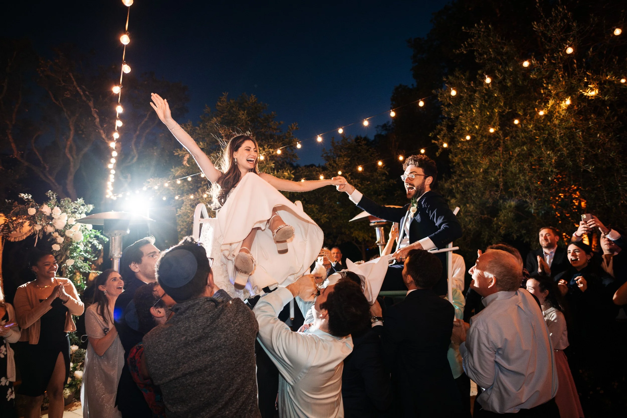 Couple lifted during the Hora at a Jewish wedding in Marin