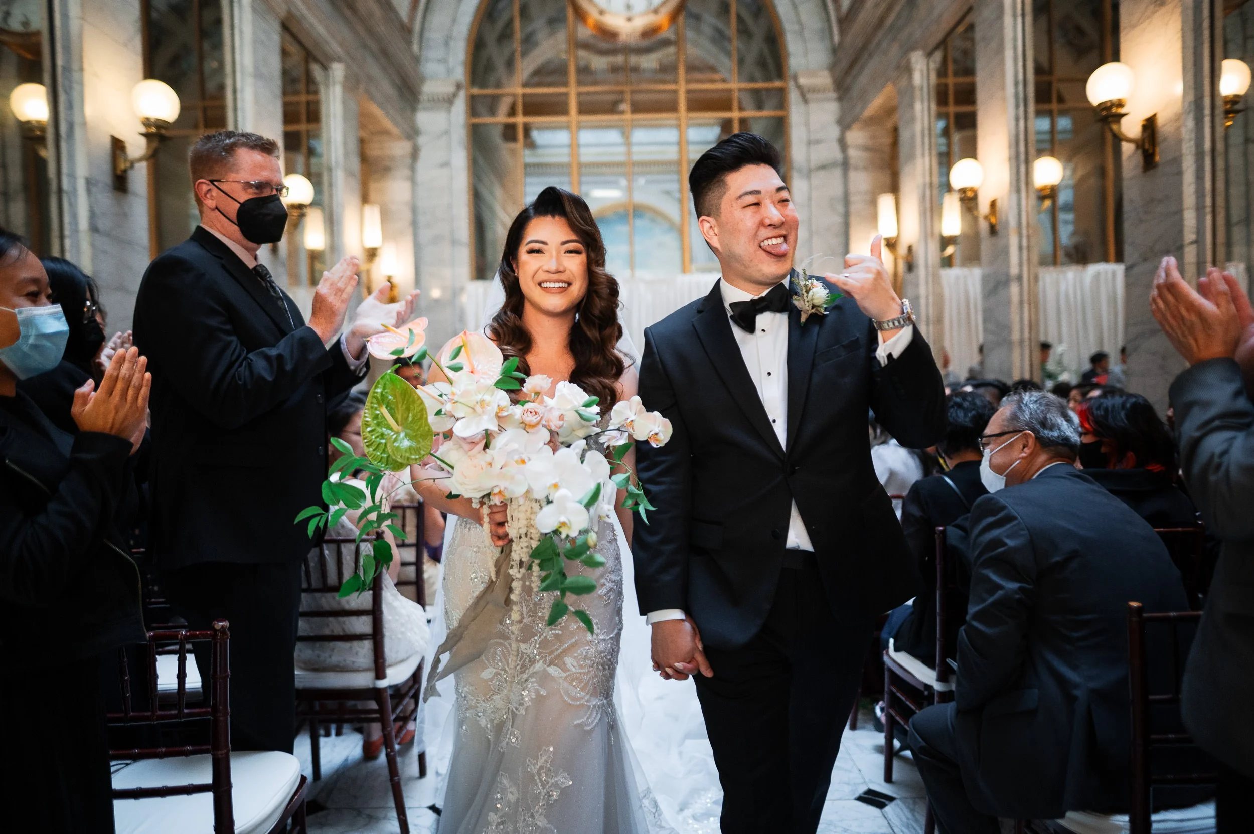 Couple happily walking down the aisle at the Merchant Exchange Building in San Francisco