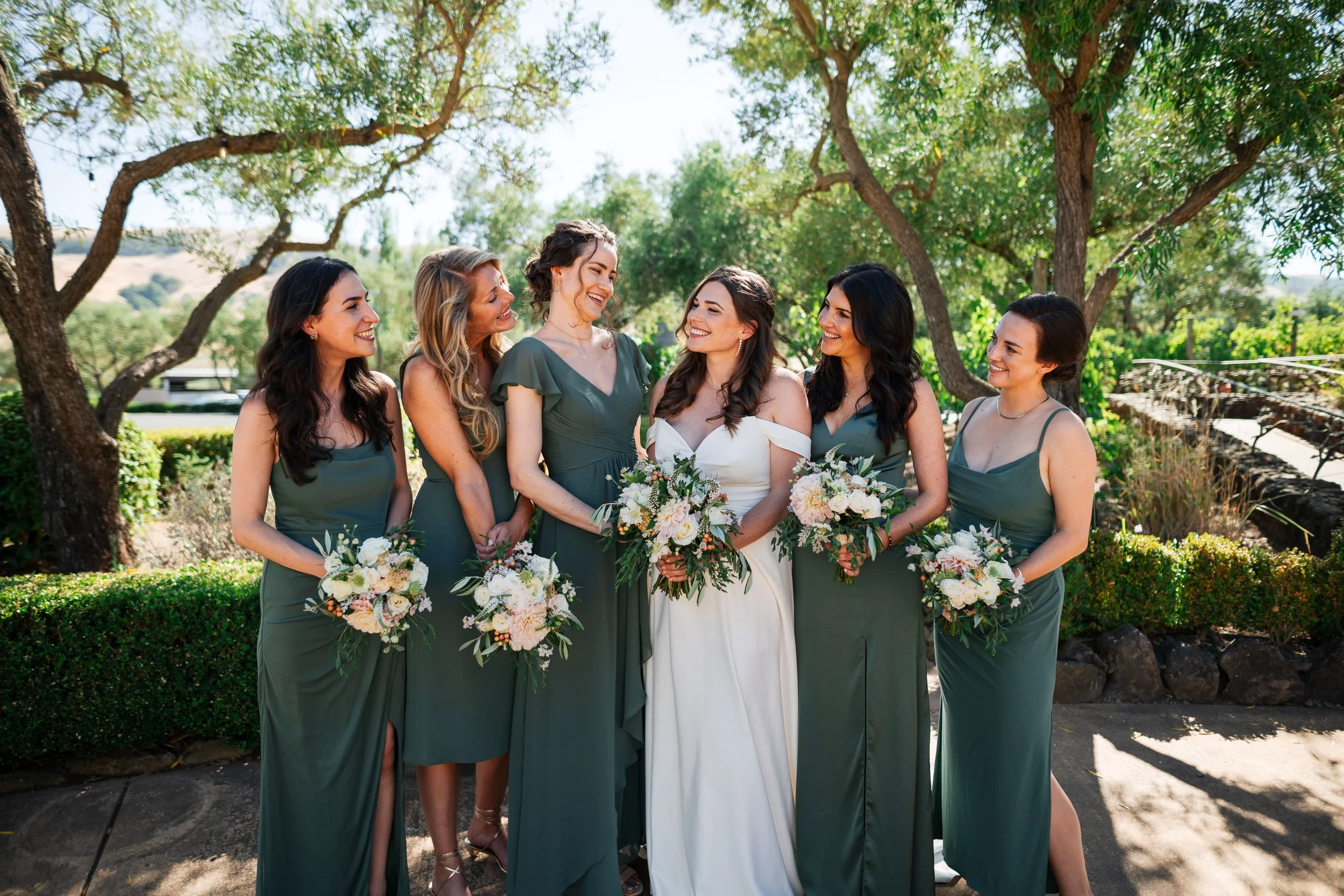 Bridesmaids look longingly at their close friend, the bride