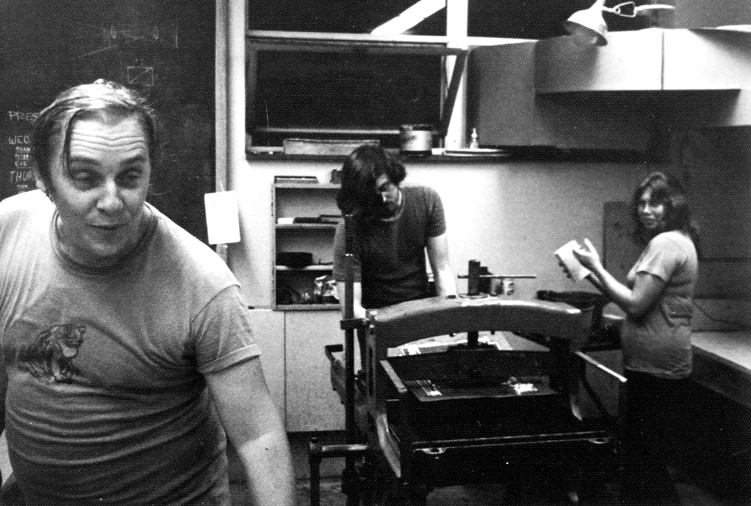 Jack examines prints, and Sondra assists printer Roger Bailey. It is late July, 1973, in the print room at St. Lawrence University in Canton, New York. 
