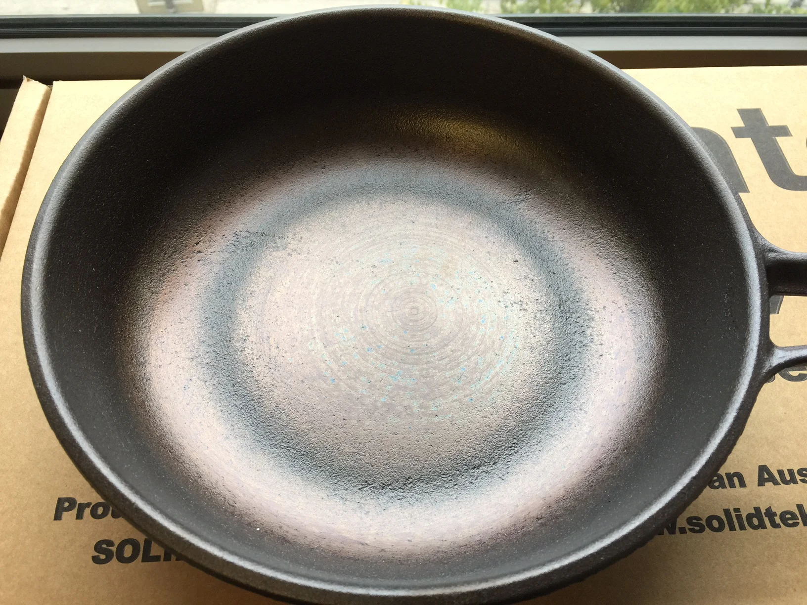 The sanded smooth base of AUSfonte pans. Sand casting always produces a naturally 'grainy' surface. We sand down the pointy tops of the texture, but why do we leave the 'pits'?