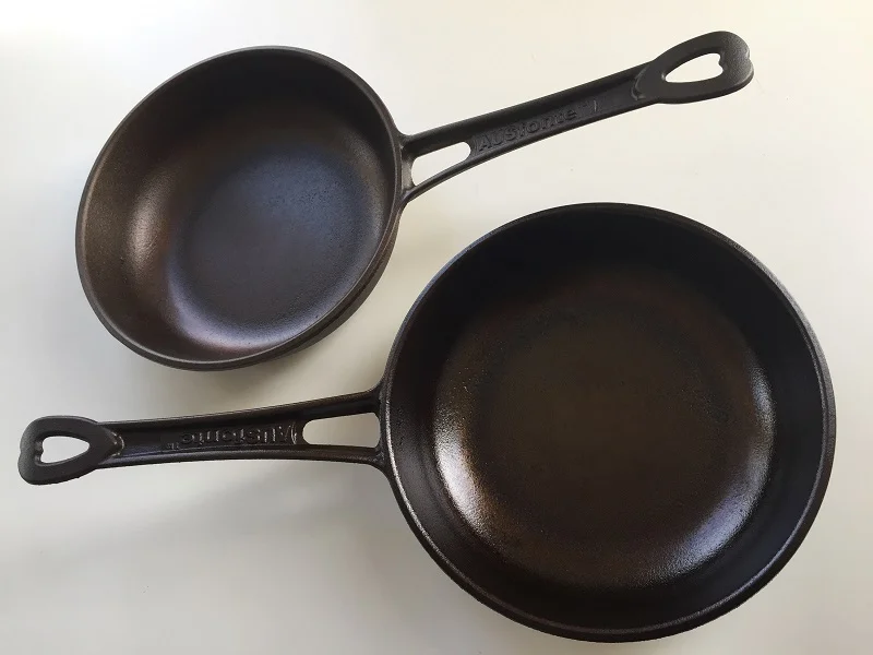 AUSfonte 24cm Sauteuse pan with light factory pre-seasoning (top), and after the recommended further 6 seasoning runs (bottom). When the pan is well-seasoned and black, the pits aren't as evident. After much more cooking they fill in and the base becomes perfectly smooth, corrosion-resistant and low-stick.
