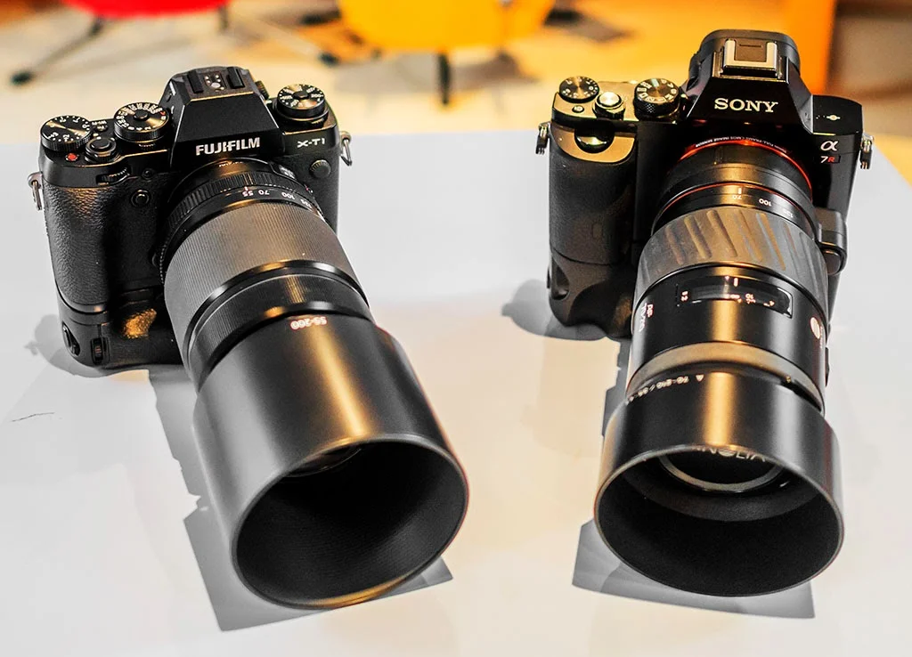 Fuji X-T1 + battery grip and 55-200mm lens compared in size to Sony A7r + nattery grip with 75-200 Minolta zoom.