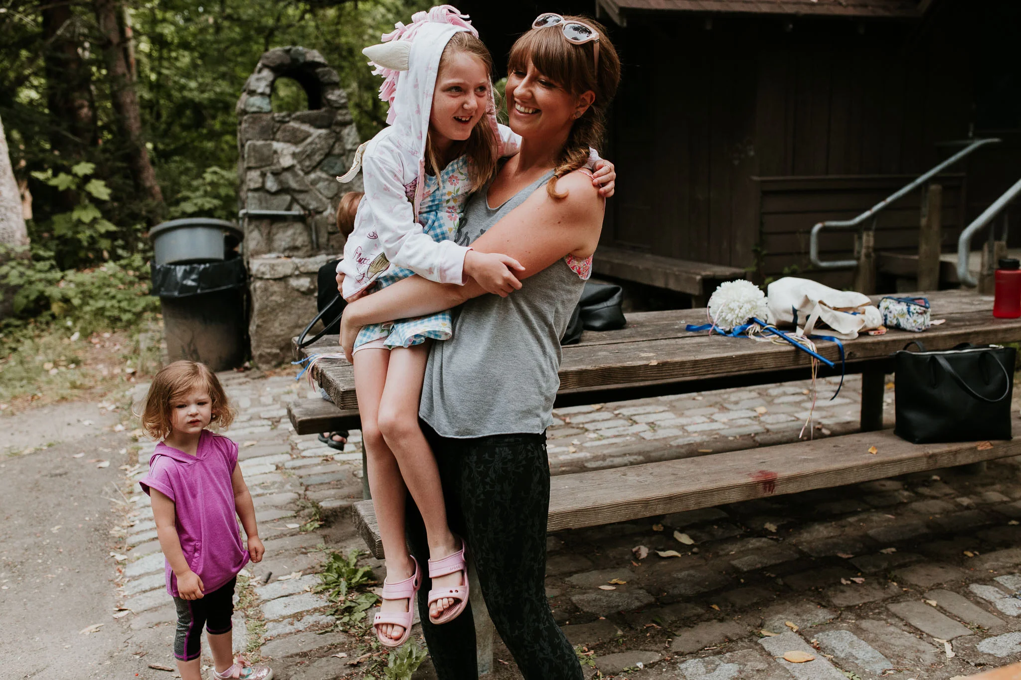candid picture of bride holding flower girl as they begin to get ready for the day