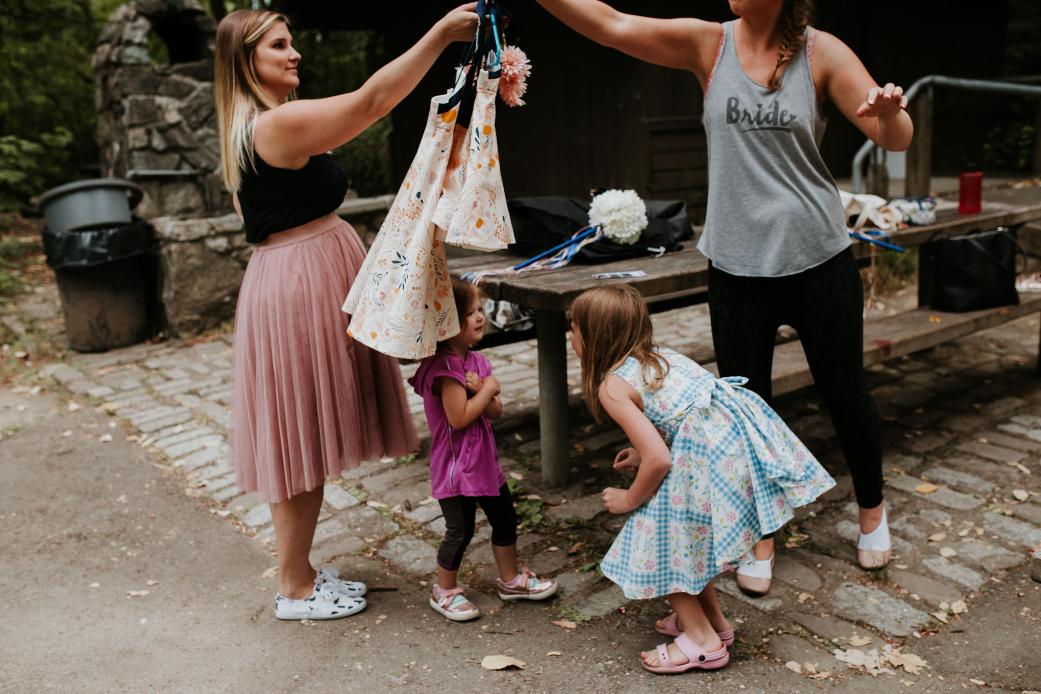 candid picture of bride holding flower girl as they begin to get ready for the day