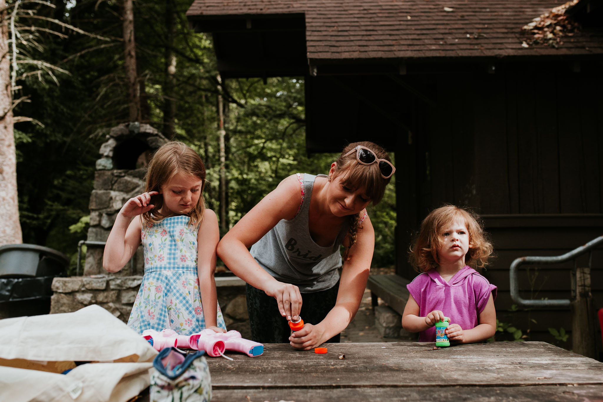 candid picture of bride holding flower girl as they begin to get ready for the day