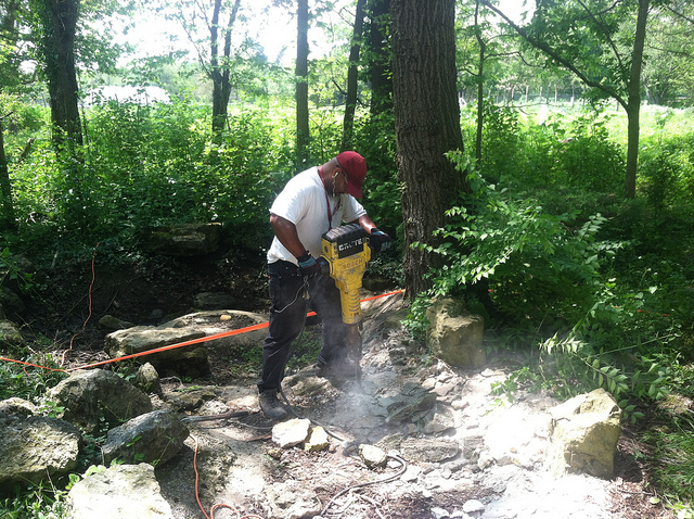 Tomaz Williams breaking apart the concrete liner of the original pond (photo by Sara Black)