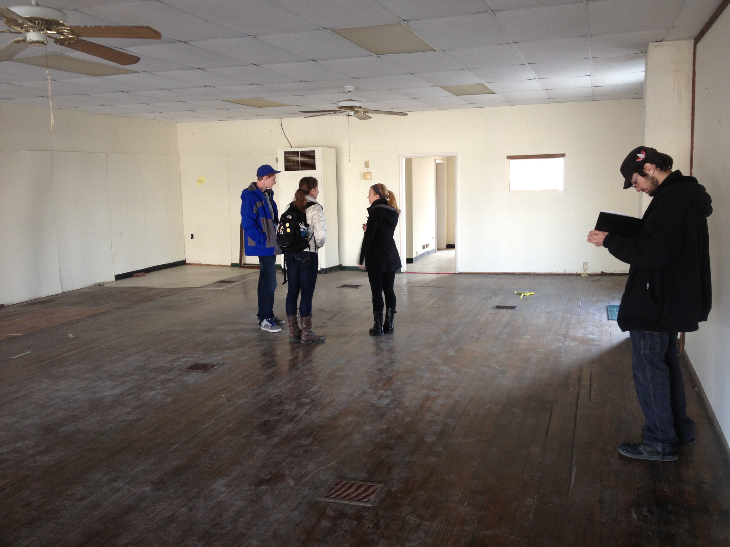 Sculptors inside of the space taking notes, measuring, and planning for their installation.