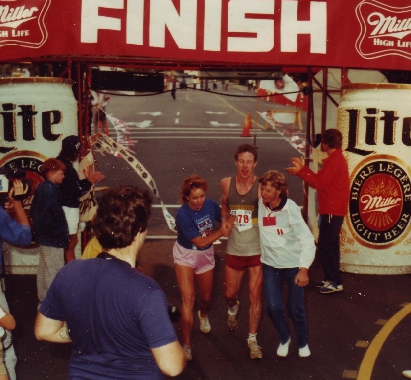 Kay Rhead helps an athlete across the Ultra finish line, August 1985