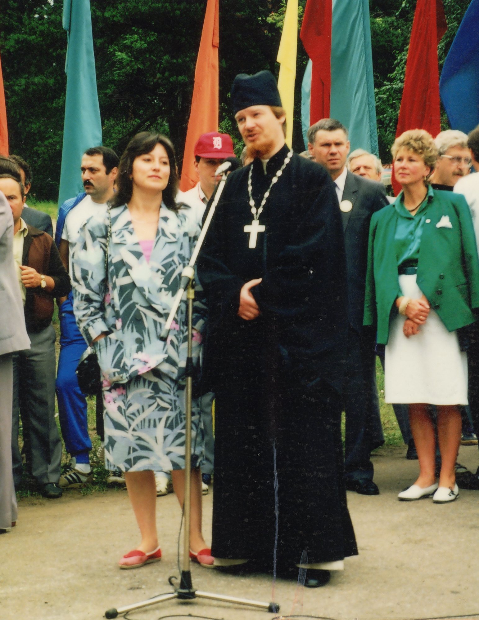 A Russian orthodox priest blesses the athletes with the translator by his side. The woman in green in the back is the mayor.