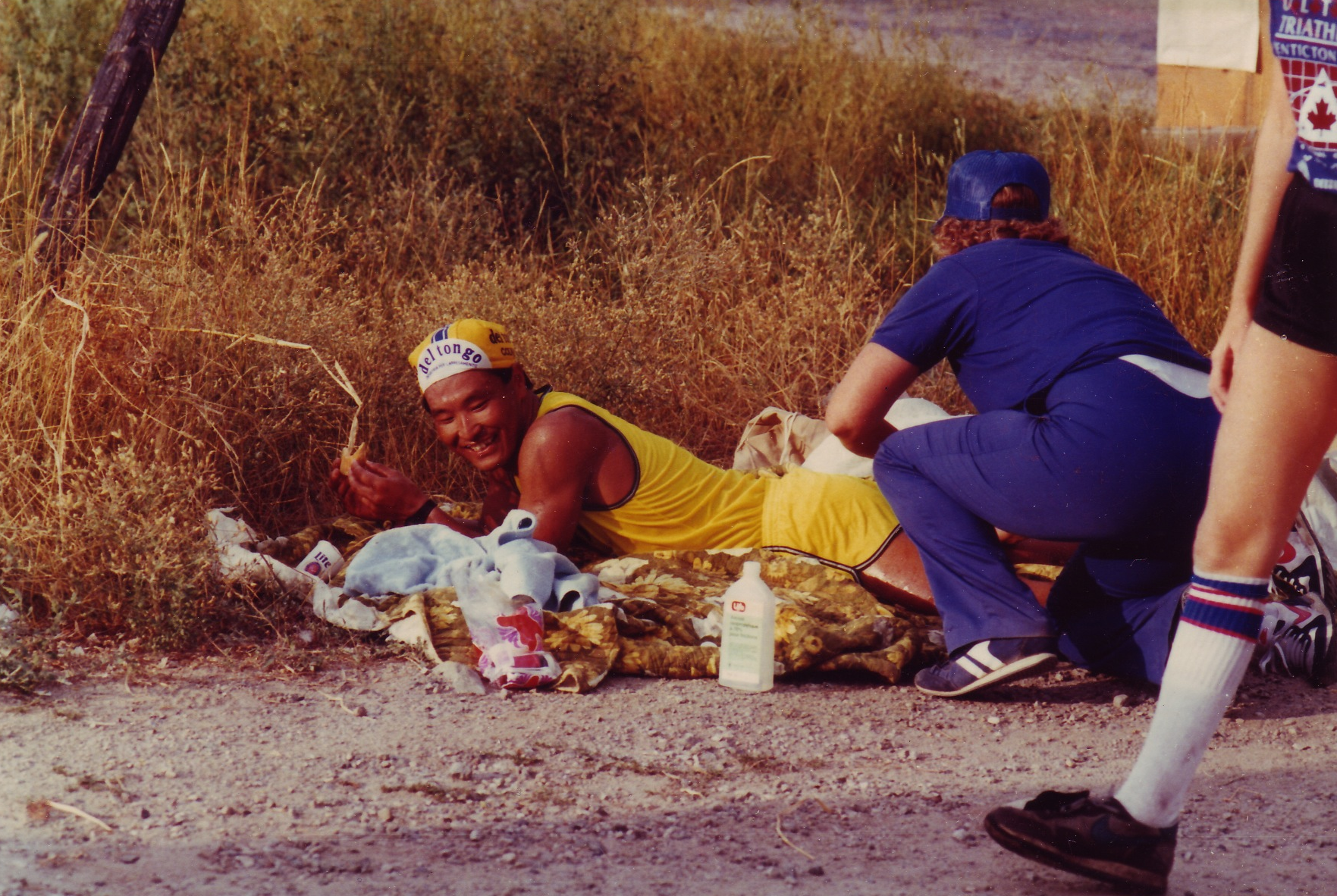 An athlete gets a leg massage from an aid station volunteer on the run course. 
